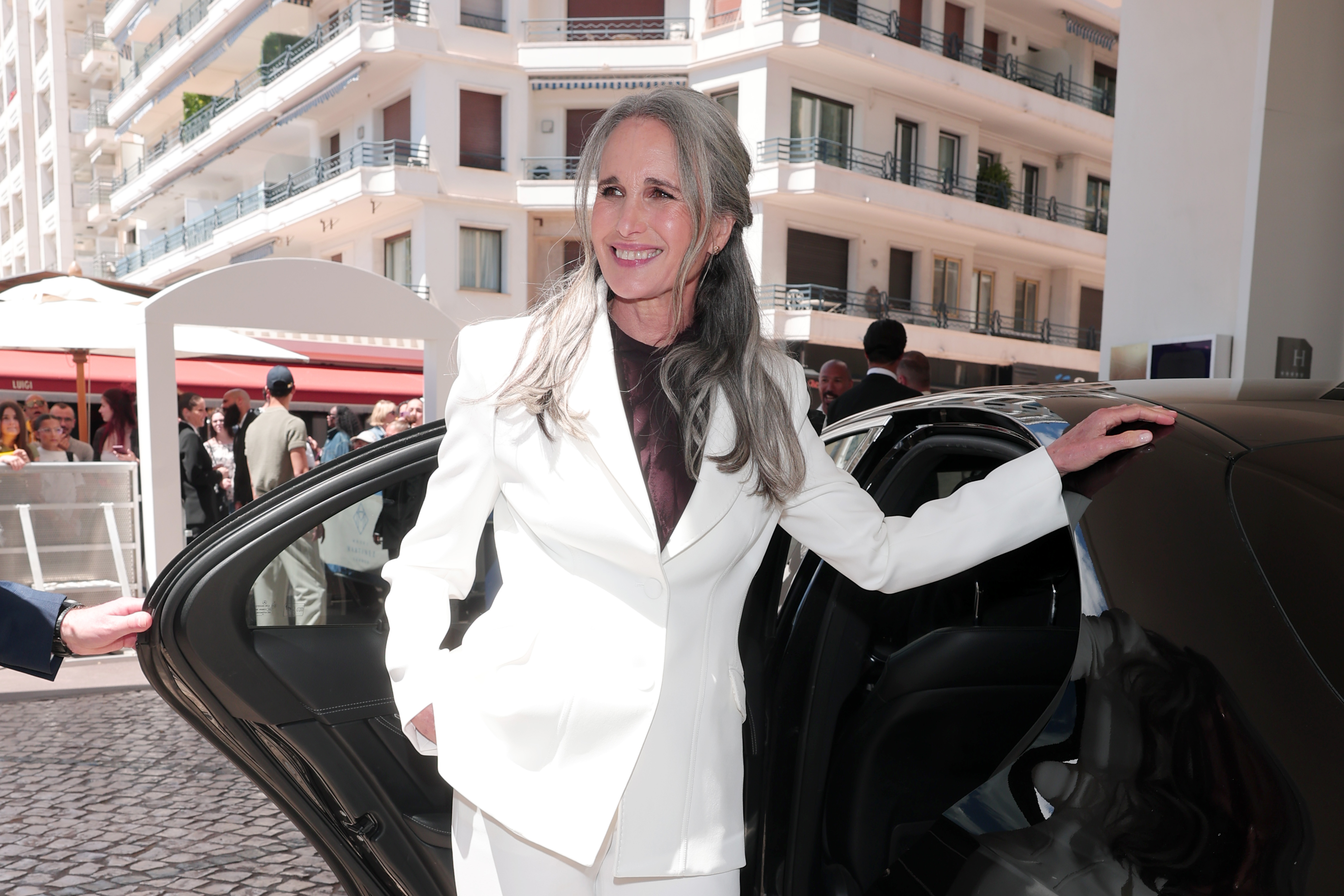 Andie MacDowell made a striking appearance at Cannes with her long silver hair styled half-up, showing how her natural gray has become part of her elegant red-carpet look. | Source: Getty Images