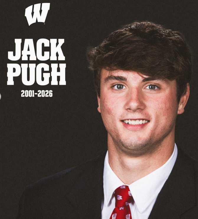 A formal portrait of Jack Pugh, dressed in a suit and tie, captures him with a composed, easy smile against a dark backdrop. | Source: Instagram/footballforever