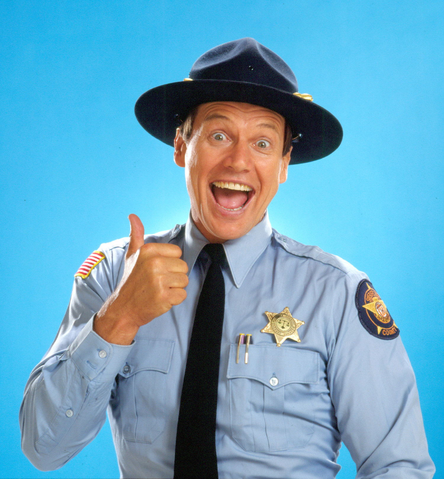 Shroyer's wide grin and thumbs-up capture the upbeat image viewers knew from Enos Strate. That cheerful screen persona made a sharp contrast with the darker characters he later played. | Source: Getty Images