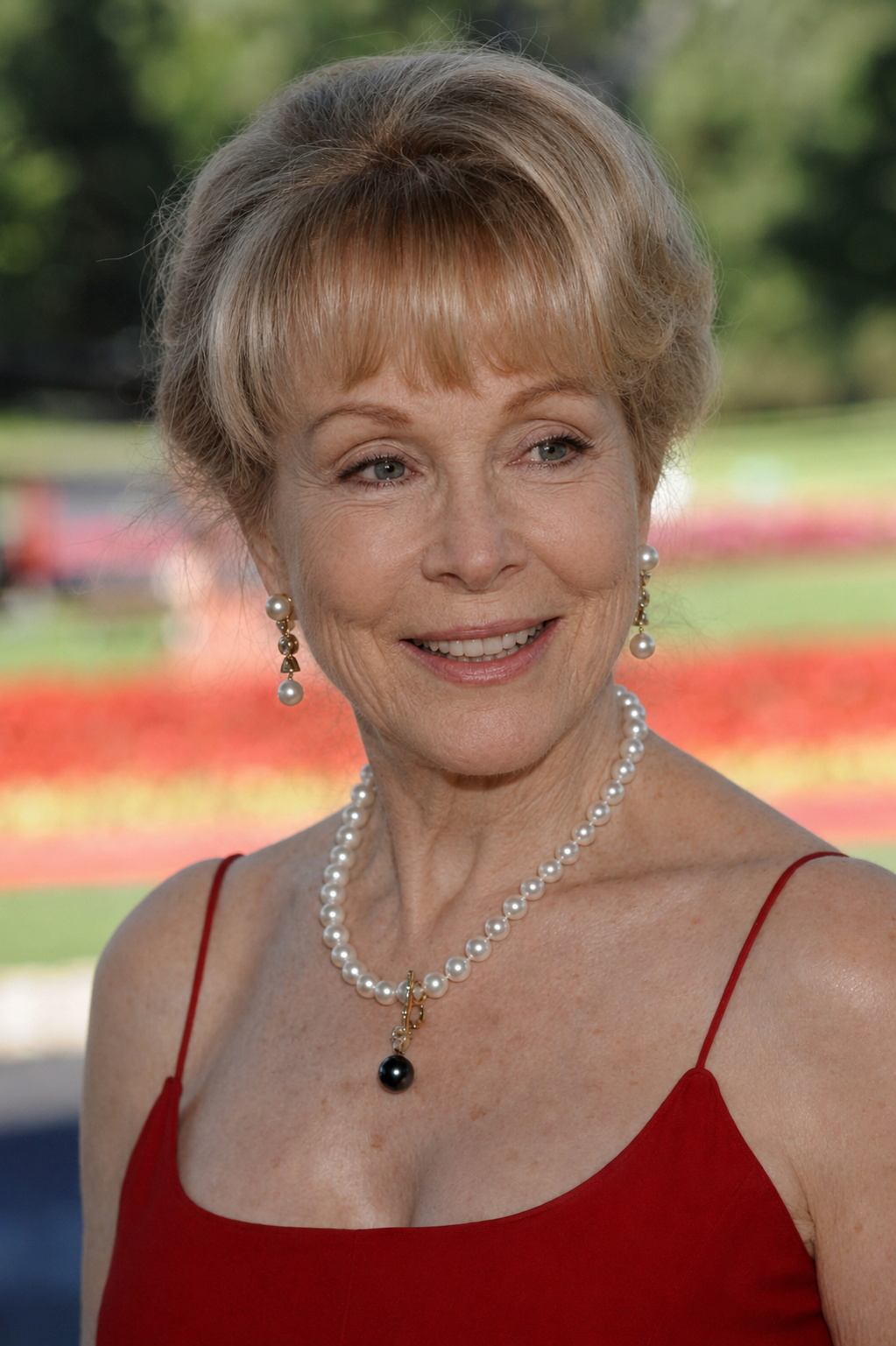 This AI-rendered portrait imagines Barbara Eden with a smoother complexion and softer facial lines while preserving her pearl jewelry, red dress, and signature hairstyle. | Source: ChatGPT