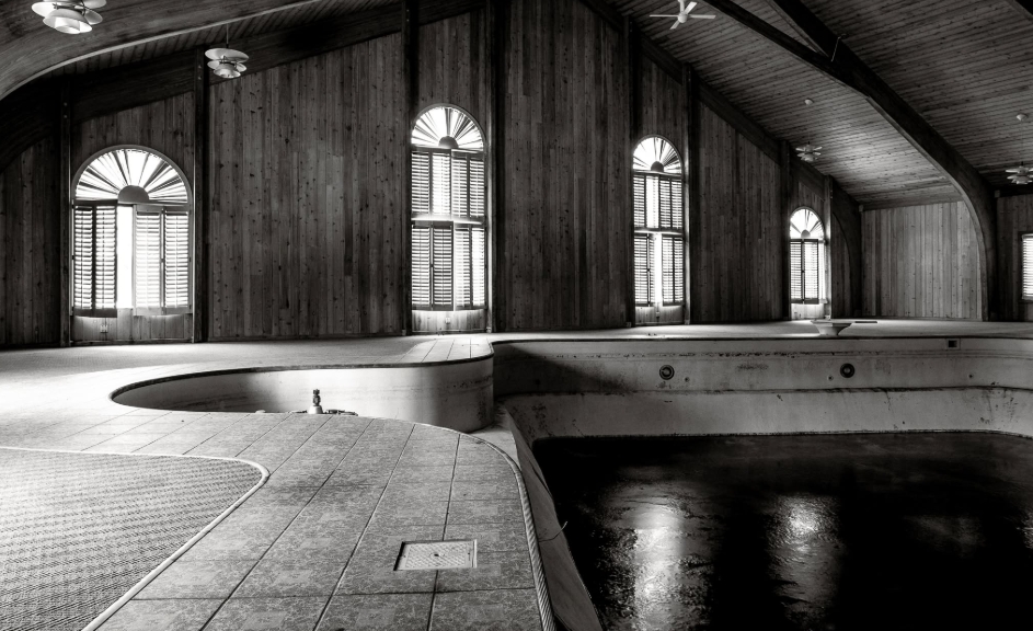 Empty pools and aging tiled surfaces reveal another perspective of the indoor recreational area at Mike Tyson's former Ohio property. Tall shuttered windows run along the wood-paneled walls, allowing daylight into a space that had visibly deteriorated during the years it stood unused. Living Word Sanctuary Church later identified this substantial section of the mansion as the location for its sanctuary. | Source: Facebook/Johnny Joo