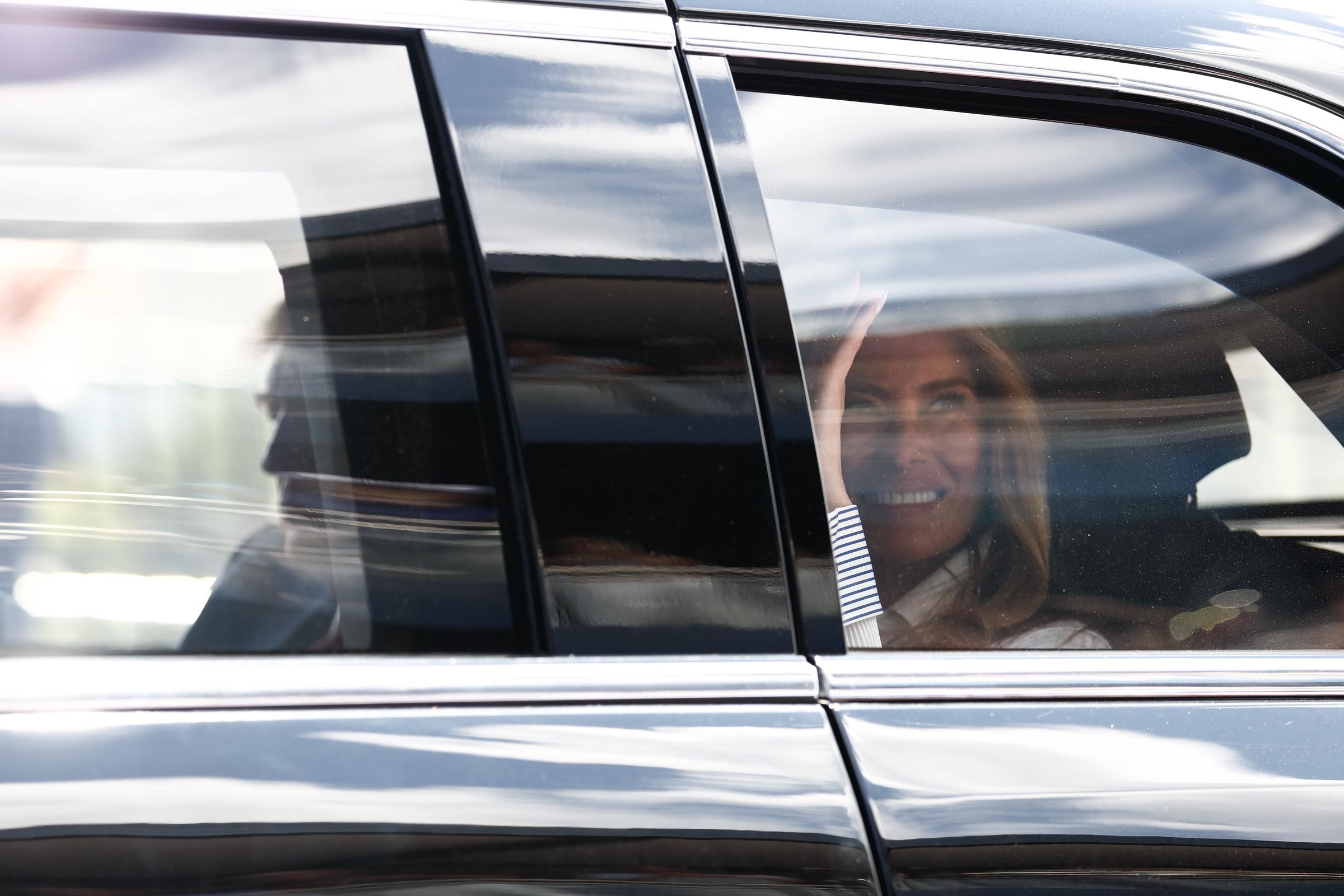 Donald Trump and Melania Trump arrived to greet spectators along the track. In this photo, they waved to fans during the NTT INDYCAR Series Freedom 250 on August 23, 2026, in Washington, D.C. | Source: Getty Images