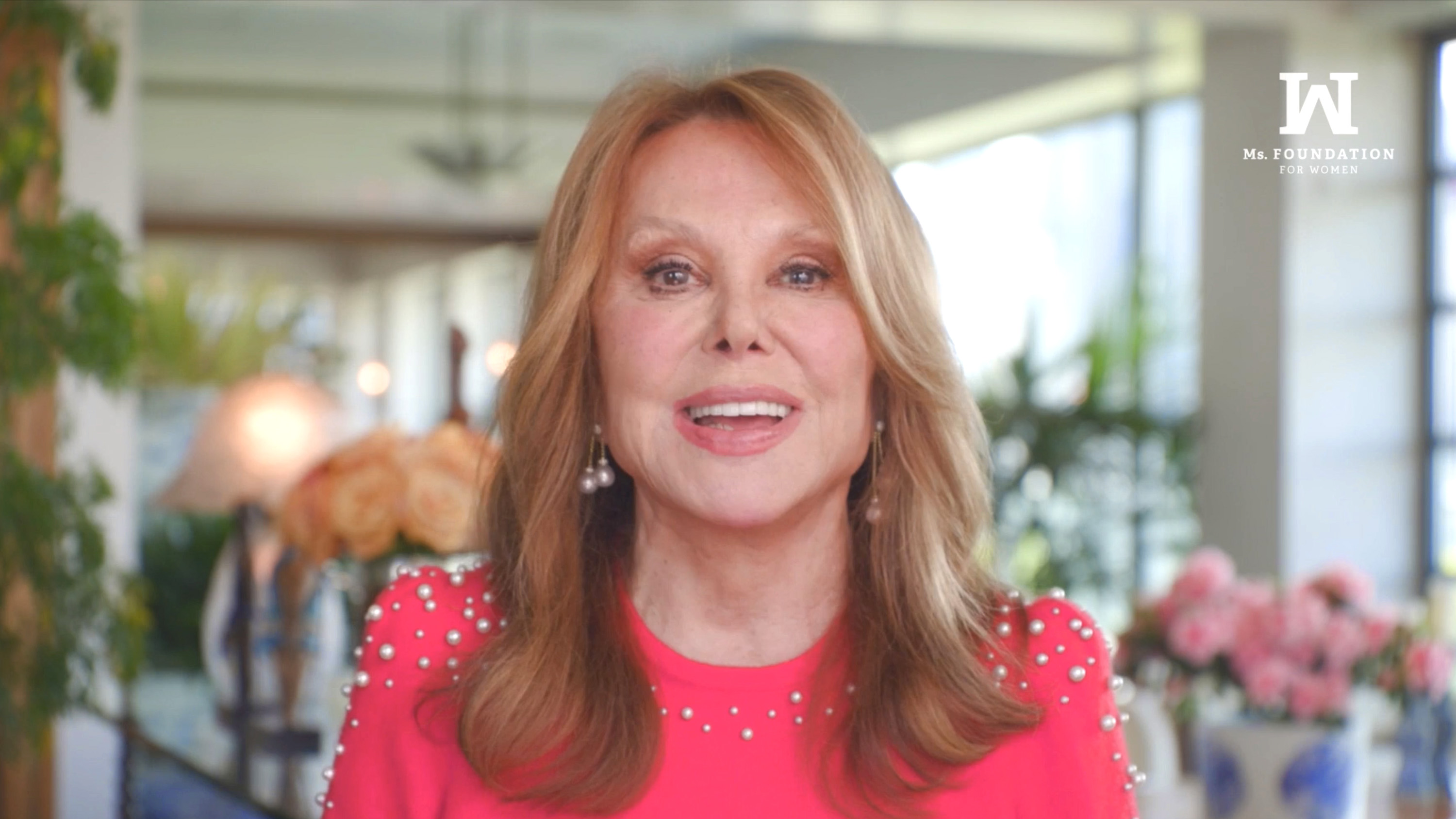 Marlo Thomas speaks during the virtual 33rd Gloria Awards: A Salute to Women of Vision, wearing a vibrant pink embellished top as she addresses viewers from a bright, flower-filled setting. | Source: Getty Images