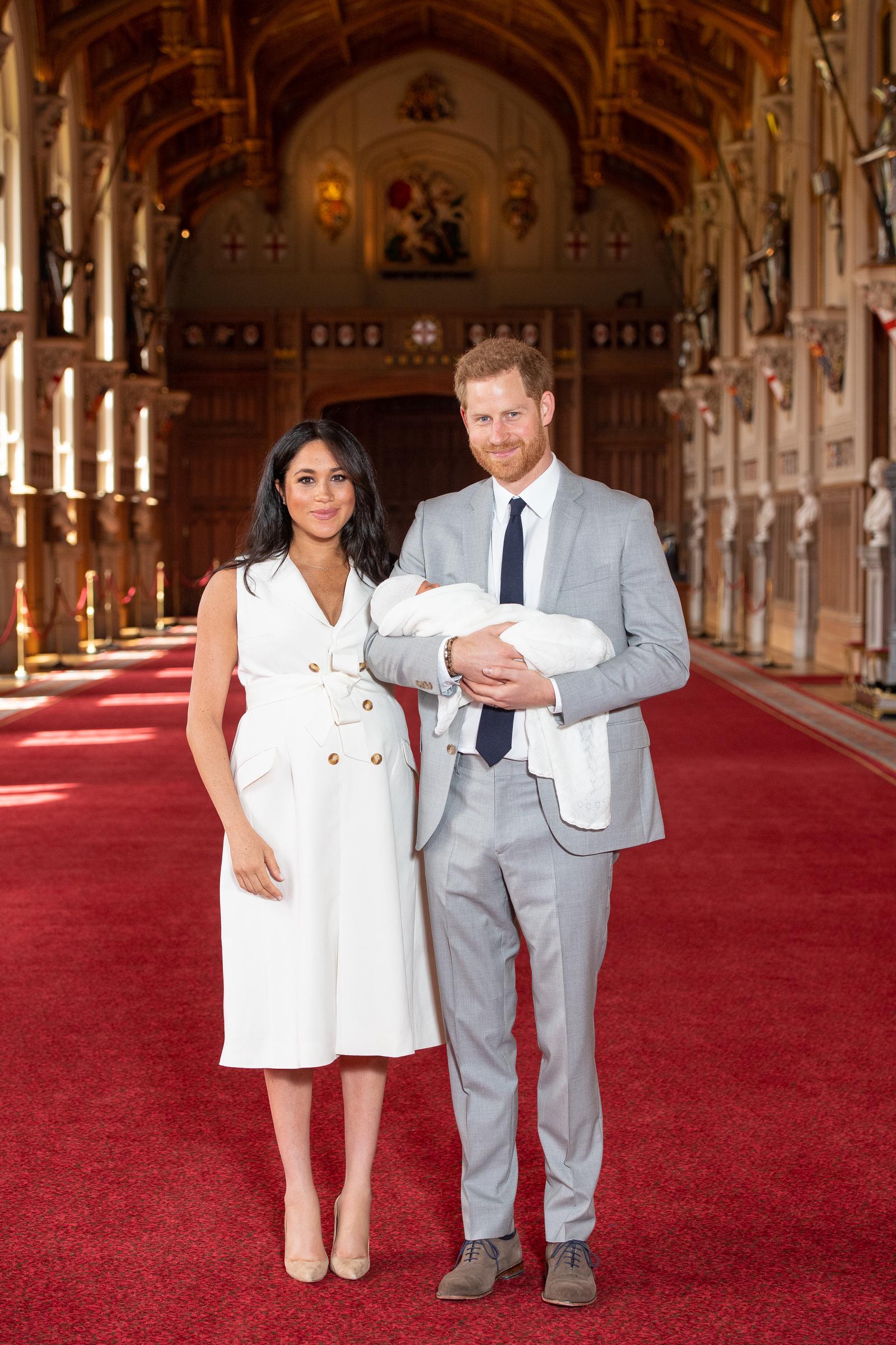 Prince Harry, Duke of Sussex, and Meghan, Duchess of Sussex, posing with their newborn son, Prince Archie, during a photocall in St. George's Hall at Windsor Castle on May 8, 2019, in England. | Source: Getty Images
