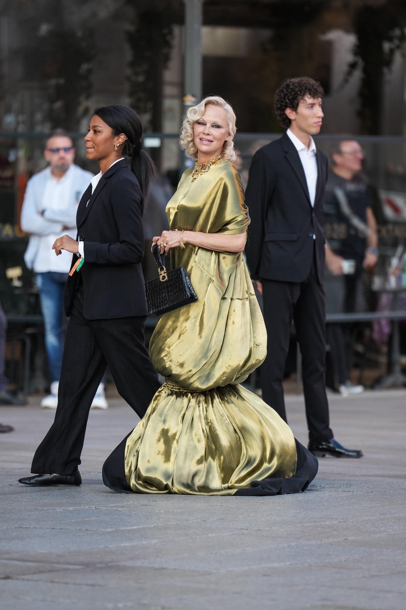 Anderson walks toward the showcase with her handbag in hand, revealing the gown's dramatic balloon skirt as it pools close to the ground. | Source: Getty Images