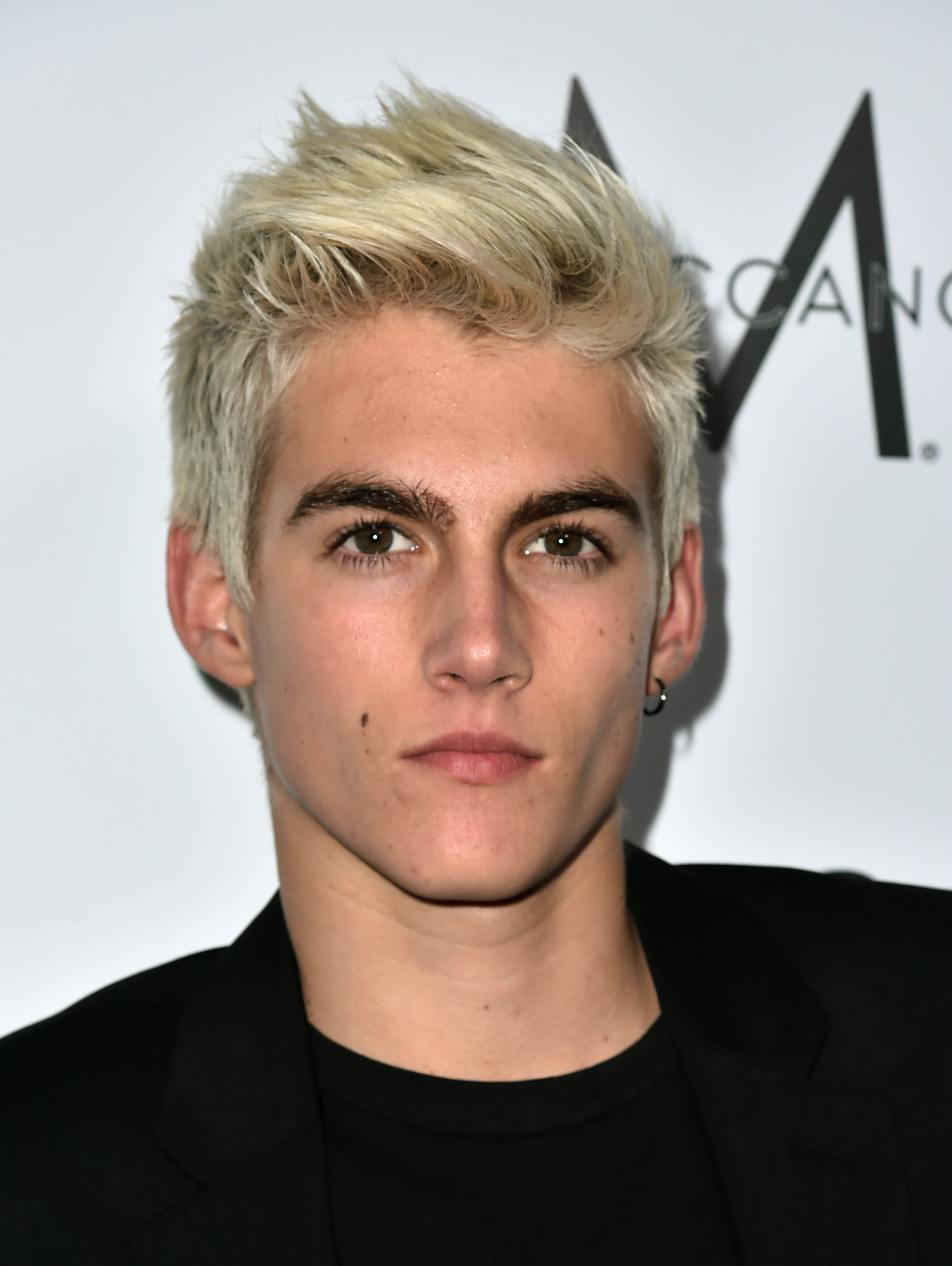 Model Presley Gerber debuted a striking bleached-blonde crop and a subtle hoop earring as he arrived in an all-black ensemble for The Daily Front Row "Fashion Los Angeles Awards" at the Sunset Tower Hotel on March 20, 2016, in West Hollywood, California. | Source: Getty Images