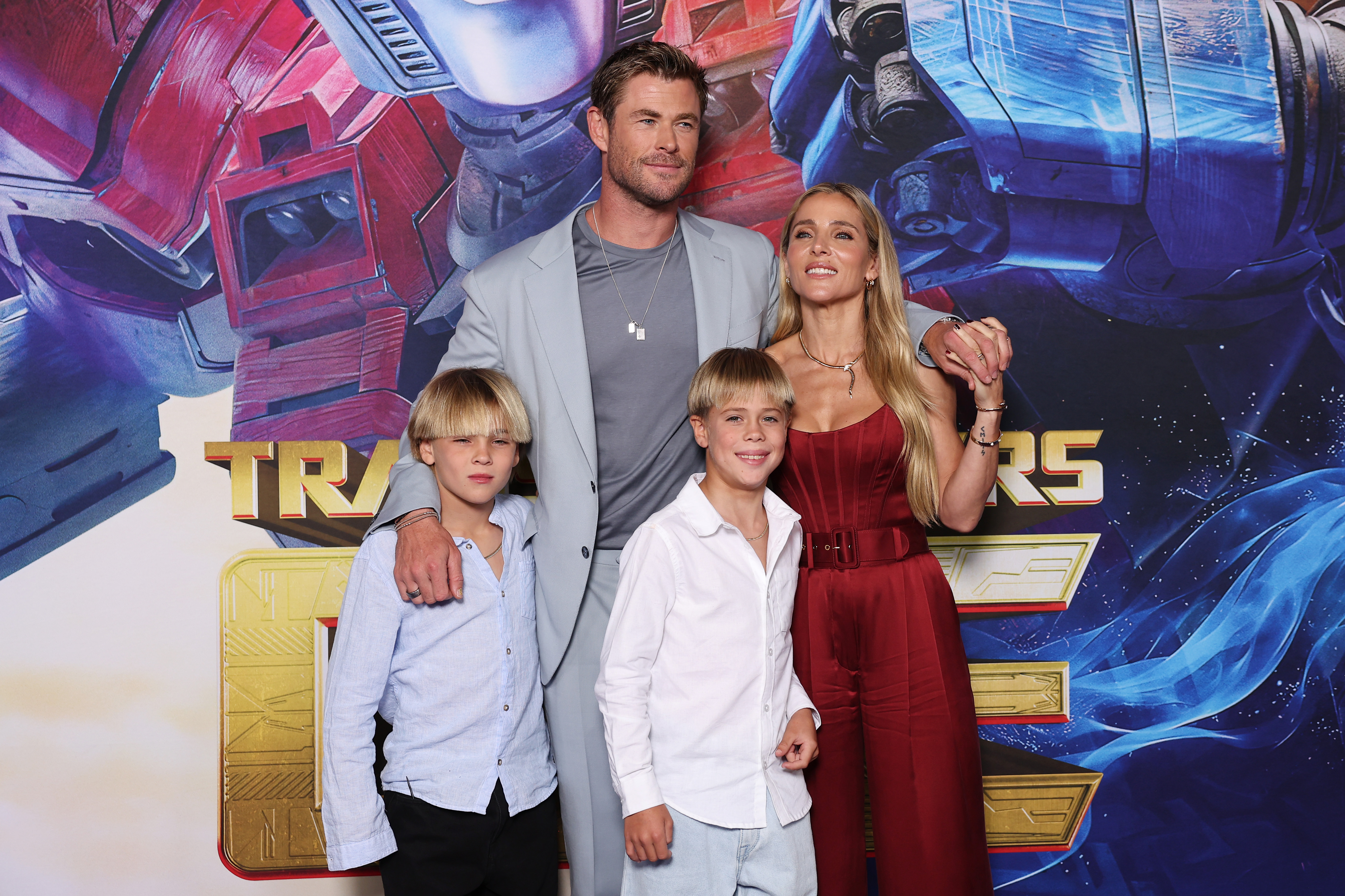 Chris Hemsworth and Elsa Pataky pose with their twin sons, Tristan and Sasha, at the Australian premiere of "Transformers One" at IMAX Darling Harbour on September 11, 2024. Chris wore a light grey suit over a gray tee, while Elsa stunned in a strapless red jumpsuit. The twins matched in button-down shirts and bowl-cut hairstyles as they stood smiling beside their parents.