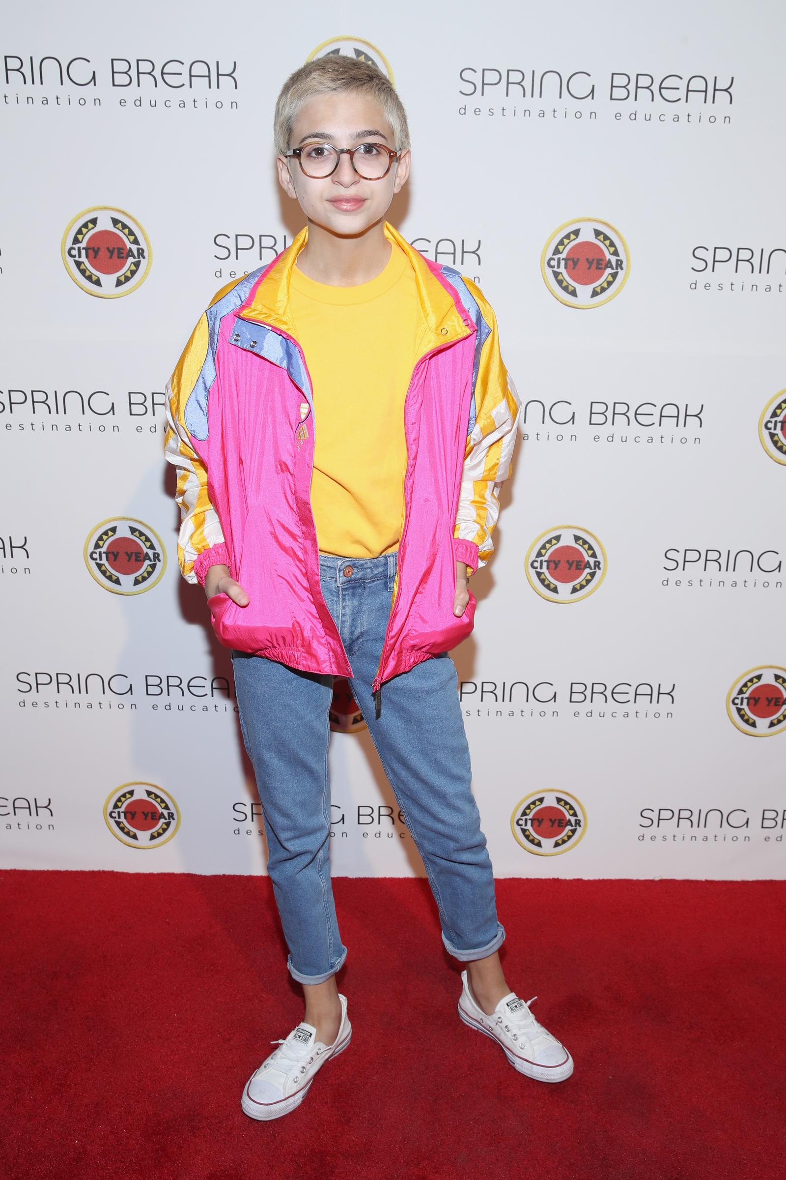 J.J. Totah attends City Year Los Angeles' Spring Break: Destination Education event at Sony Studios in Los Angeles, California, wearing a vibrant pink, yellow, and blue jacket over a yellow shirt, paired with cuffed jeans, white sneakers, and round glasses. | Source: Getty Images