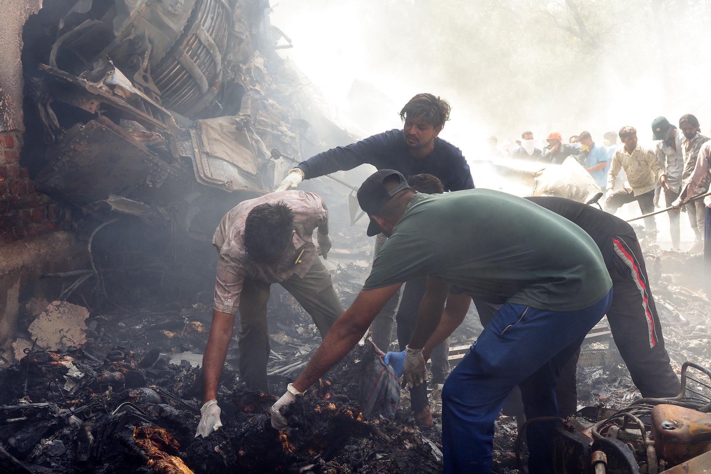 Rescue officials work at the site where Air India Flight 171 crashed in a residential area near Ahmedabad airport. | Source: Getty Images