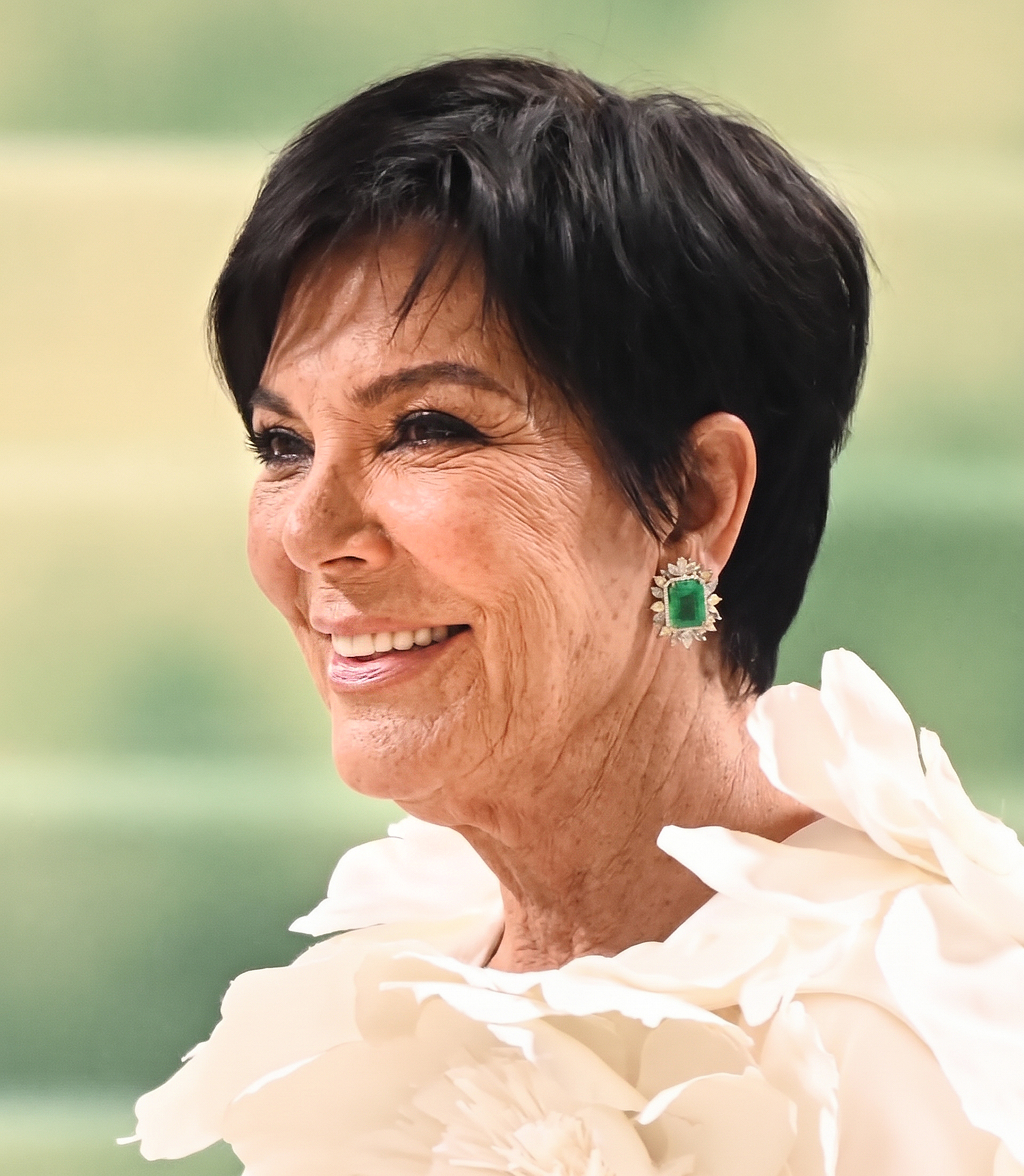 A smiling Kris in an elaborate white look and emerald-green earrings completes the first AI set, with natural wrinkles adding another dimension to the glamorous portrait. | Source: Gemini