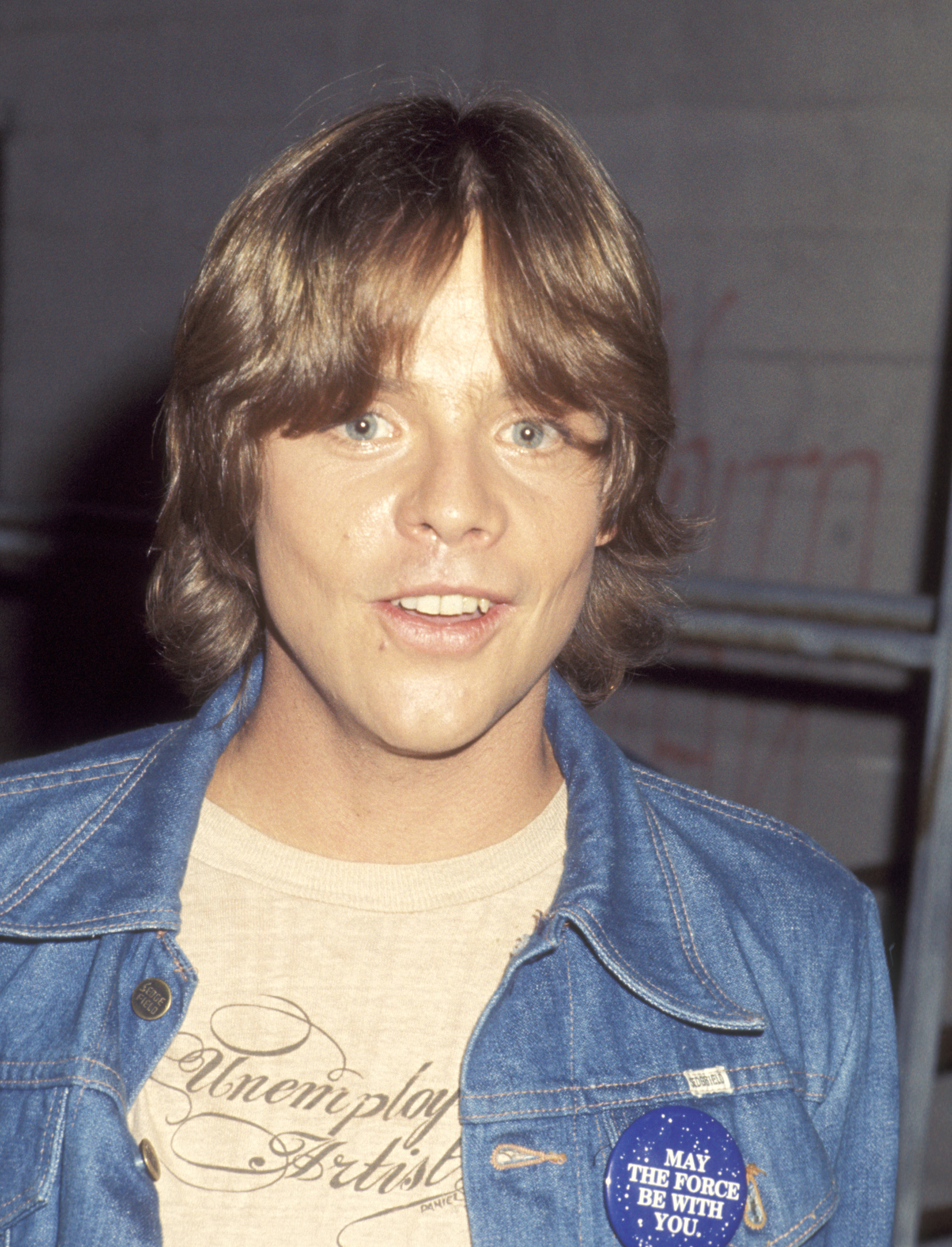 Mark Hamill appeared at a taping of "The Merv Griffin Show" at the TAV Celebrity Theater in Hollywood, California, on June 7, 1977, just weeks after "Star Wars" reached theaters. Wearing a denim jacket with a "May the Force Be With You" button, Hamill was photographed several months after his car crash and reconstructive treatment. The photograph captured the 25-year-old actor as his newfound fame as Luke Skywalker was rapidly taking hold.