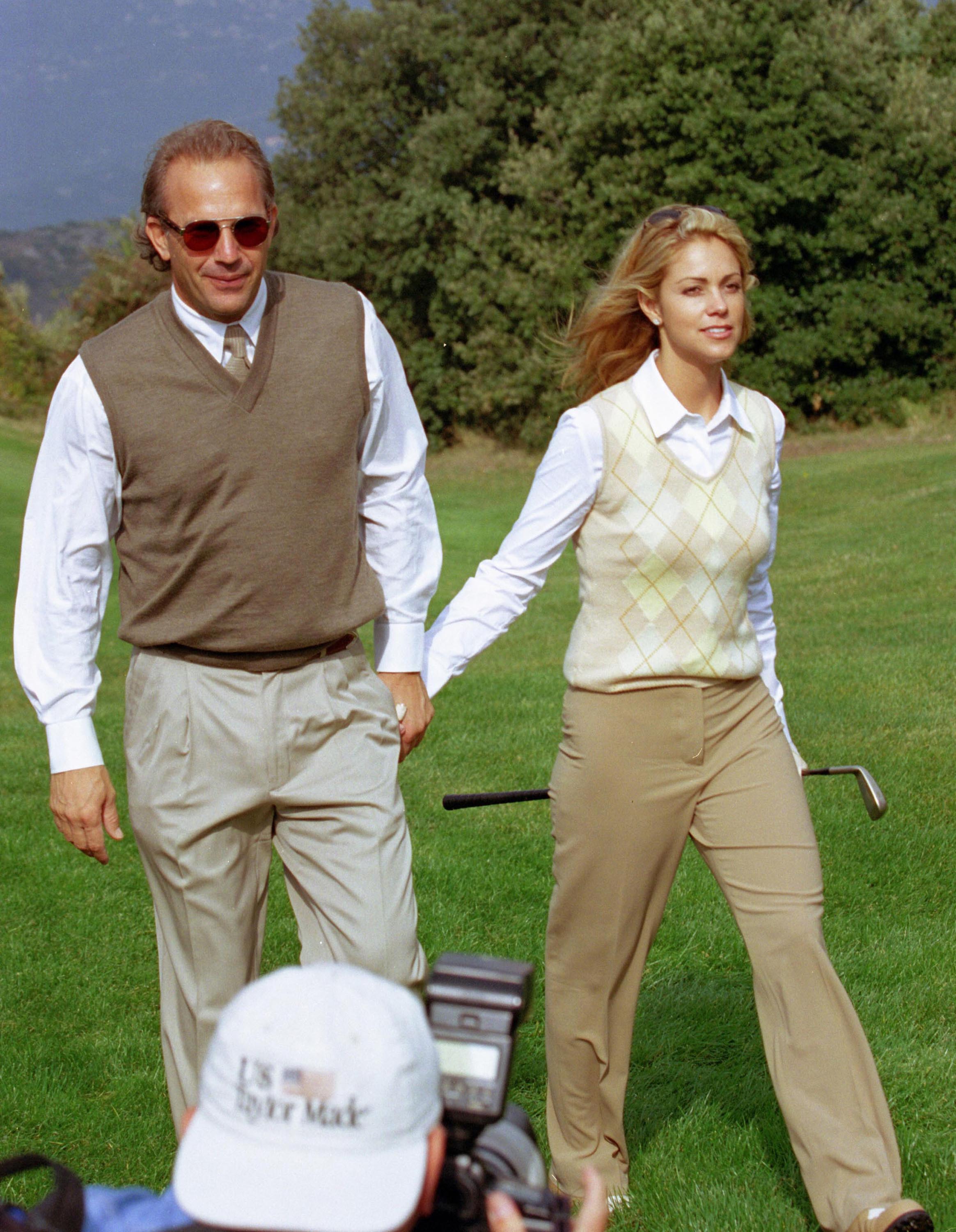 Kevin Costner and Christine Baumgartner walk hand in hand during the Big 3 Records Monte Carlo Invitational Pro-Celebrity Golf Tournament at Monte Carlo Golf Club in Monaco on October 6, 2000. By then, the couple had reconnected after first meeting several years earlier and were building the relationship that would eventually lead to marriage.