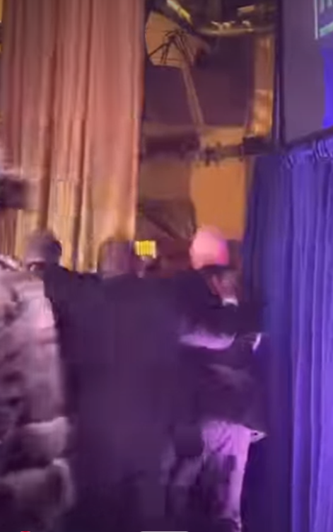 President Donald Trump is swiftly escorted out through a backstage exit by multiple agents, who guide and shield him while clearing a path away. | Source: Instagram/hellomag