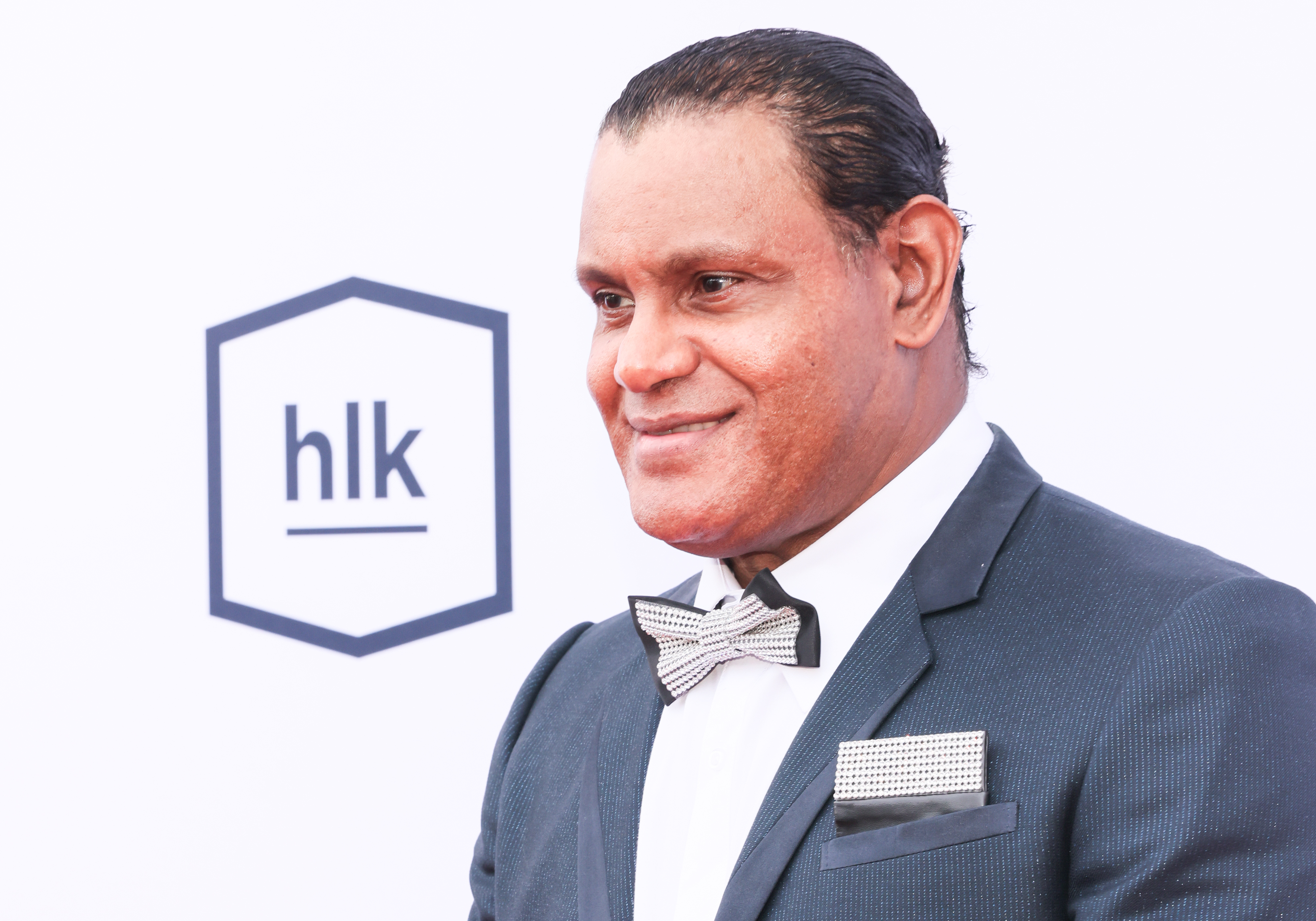 Sammy Sosa arrived in style for the Harold and Carole Pump Foundation Celebrity Dinner at The Beverly Hilton in Beverly Hills, California, on August 20, 2026. Dressed in a dark suit with a crisp white shirt, jeweled bow tie, and matching pocket square, the retired baseball star smiled while posing against the event backdrop. The appearance came as Sosa continued his renewed relationship with the Chicago Cubs.