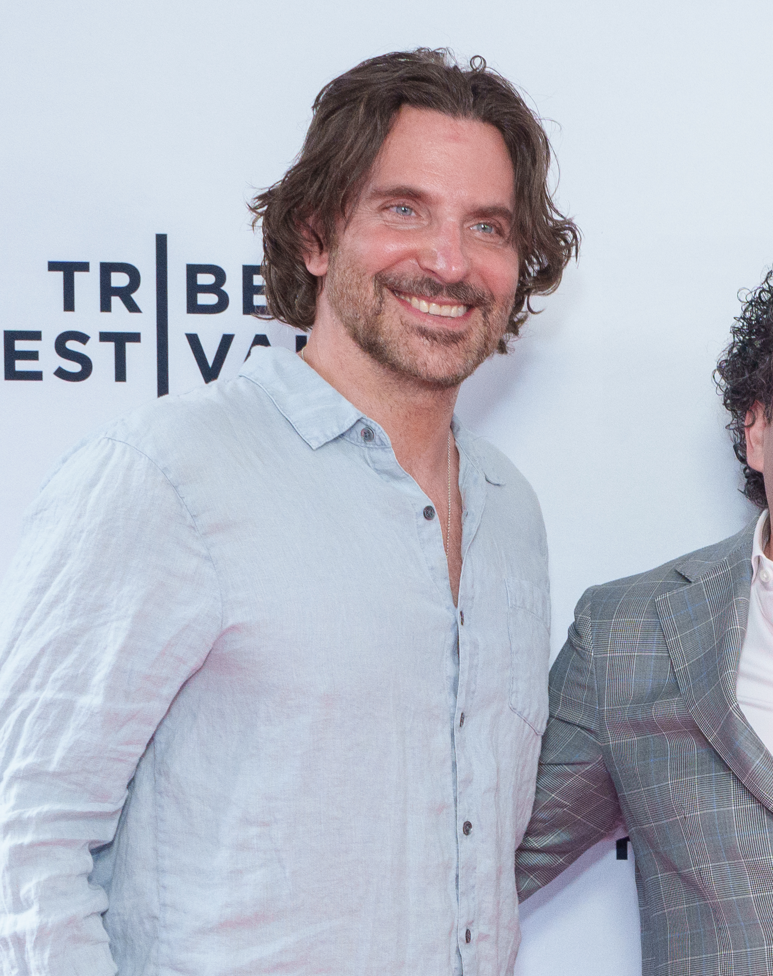 Cooper showed genuine smile that accentuated the fine lines around his blue eyes. He also wore a full, well-maintained beard with his now-signature salt-and-pepper blend, and his brown hair was long and wavy, falling softly to his shoulders, as he attended the "All We Cannot See" premiere during the 2025 Tribeca Festival at AMC 19th Street on June 8, 2025, in New York City.
