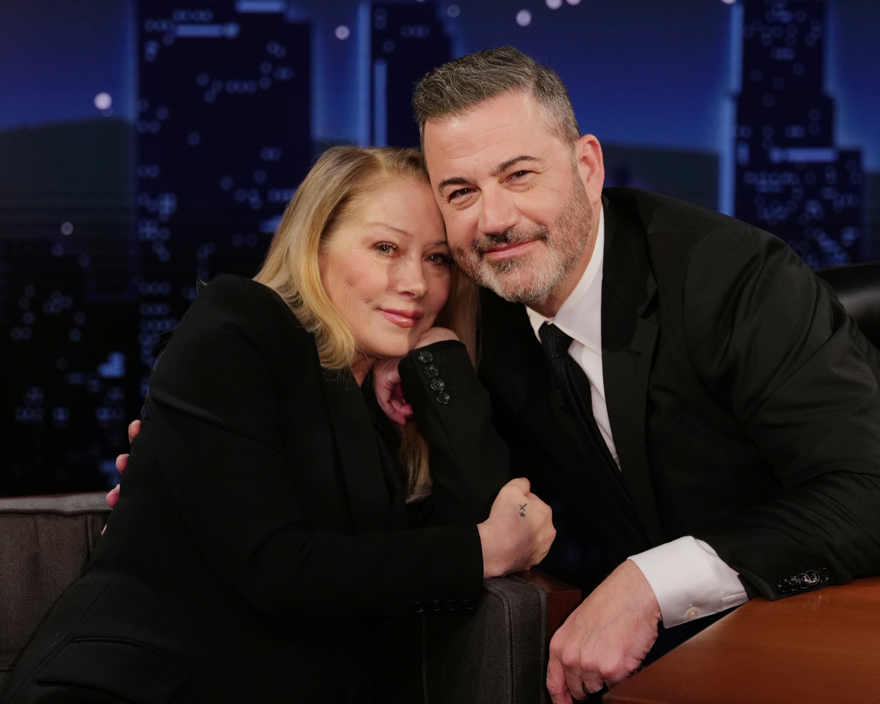 Christina Applegate leaned in close to host Jimmy Kimmel during an appearance on the late-night talk show "Jimmy Kimmel Live!" on February 23, 2026. Dressed in coordinating tailored black suits, the longtime friends shared an affectionate, relaxed moment on set, with Applegate resting her cheek against Kimmel as both smiled warmly toward the camera. | Source: Getty Images