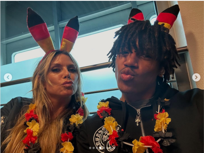 Henry and mom Heidi Klum struck playful kissy faces while wearing German-themed bunny ear headbands. Both are decked out in red, yellow, and black flower, showing off their spirited support with joy and flair | Source: Instagram/henrygunthersamuel