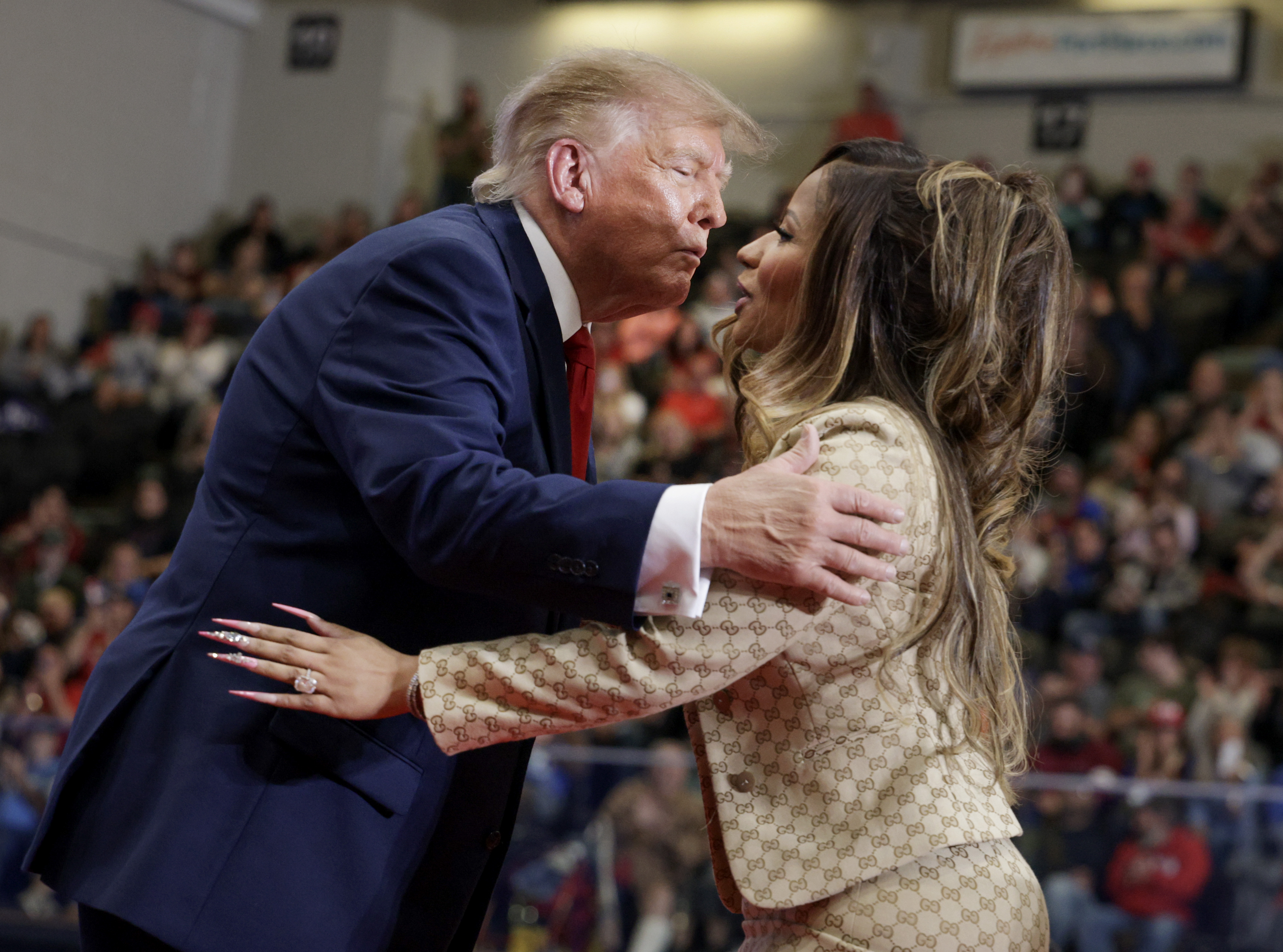 Donald Trump leans in with pursed lips as he greets Nicki Minaj onstage, their faces nearly touching while she rests a hand against his jacket — a particularly striking moment from their much-discussed interaction. | Source: Getty Images
