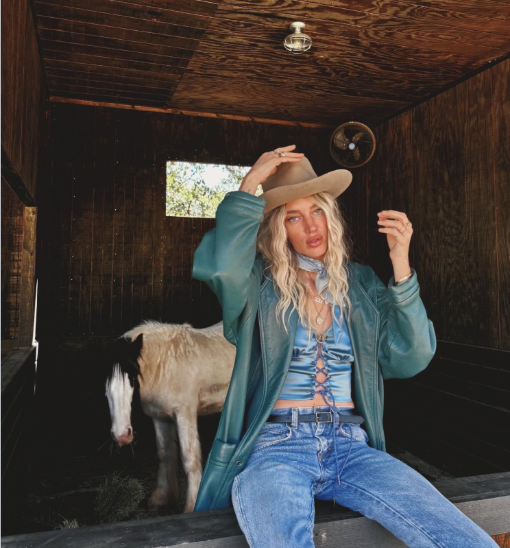 Janell Shirtcliff places a cowgirl hat on her head. | Source: Instagram/janellshirtcliff