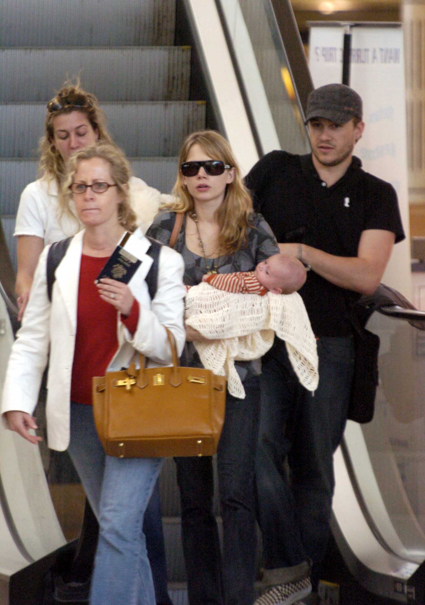 Michelle Williams and Heath Ledger arrive at Sydney International Airport in Australia with their infant daughter, Matilda Ledger, on January 14, 2006. The family was photographed just months after Matilda's birth, during a period when the actors were balancing their growing careers with life as new parents.
