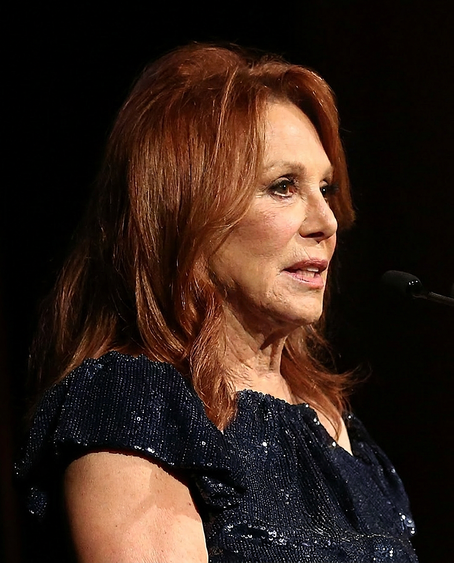 Marlo Thomas speaks at an event in an AI-generated image imagining how the actress might look without rumored cosmetic enhancements. | Source: Nano Banana