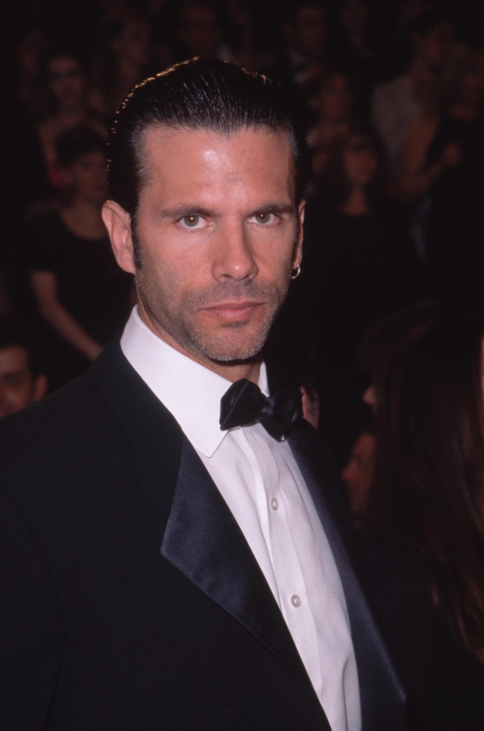 Lorenzo Lamas attends the American Comedy Awards at the Shrine Exposition Center in Los Angeles, California, on February 6, 2000. Turning toward the camera with an intense stare and light facial stubble, the actor sports slicked-back dark hair, a small hoop earring, and a classic black tuxedo featuring satin lapels and a crisp black bow tie. | Source: Getty Images
