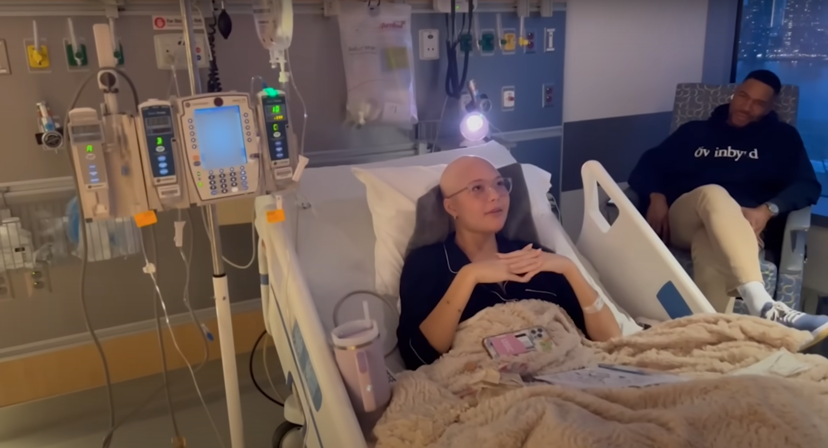 Isabella Strahan rests in a hospital bed with her father, Michael Strahan, by her side during her cancer treatment in 2024. | Source: YouTube/@IsabellaStrahan