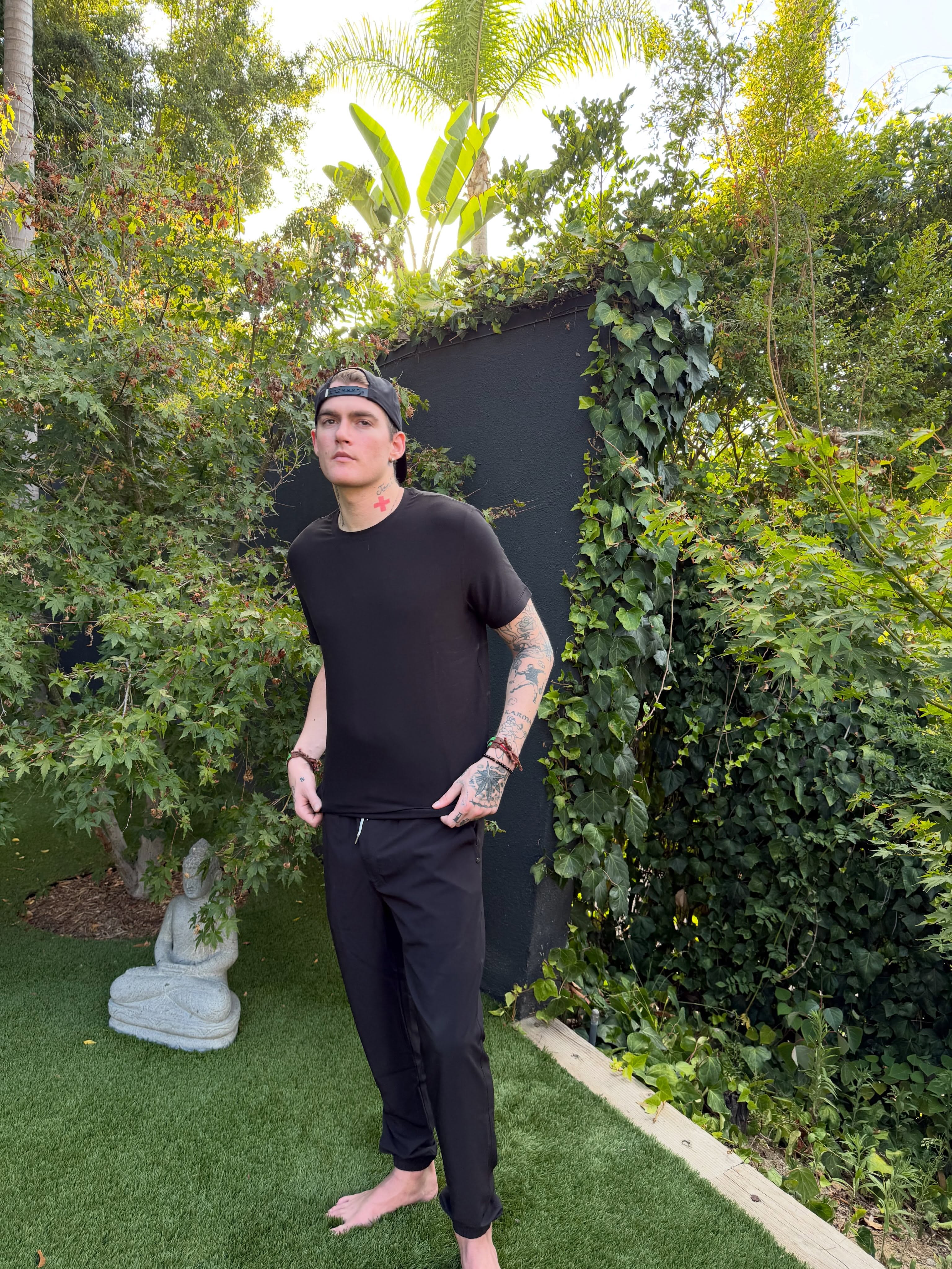 Standing casually on the lush garden lawn, Presley Gerber adjusts his outfit in a frame from his final social media upload. | Source: Instagram/presleygerber