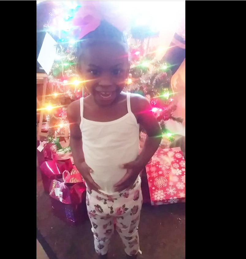 A photo of one of Shamar Elkins’s children shows her beaming in front of a glowing Christmas tree, hands resting confidently as colorful lights shimmer around her. | Source: Facebook/Shaneiqua Elkins