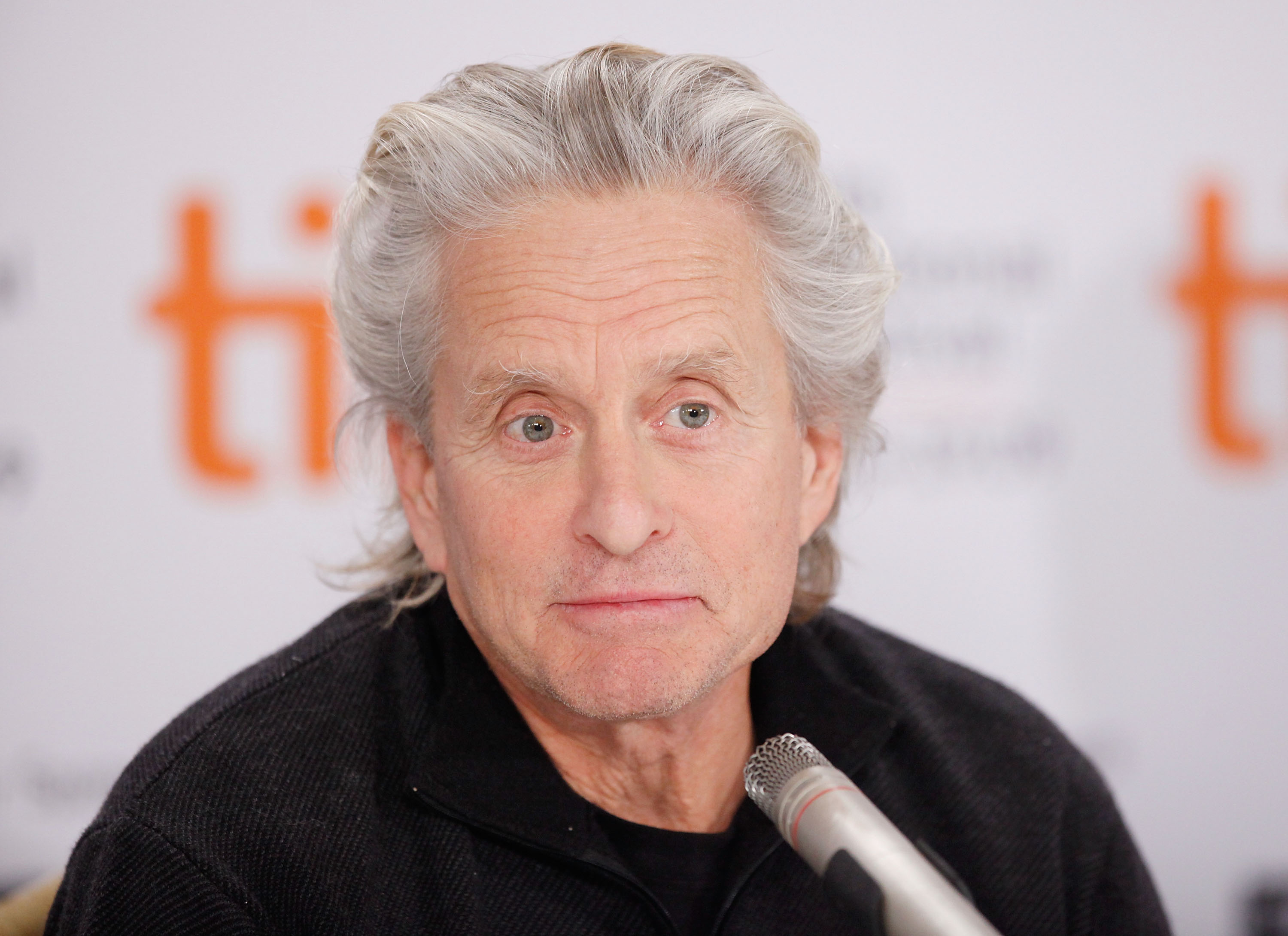 By September 12, 2009, Douglas was promoting "Solitary Man" at the Toronto International Film Festival in Canada. Photographed during the movie's press conference at the Sutton Place Hotel, he appeared with longer silver hair and wore a black sweater while speaking into a microphone. The event took place less than a year before doctors diagnosed the actor with stage four cancer and he began eight weeks of treatment.