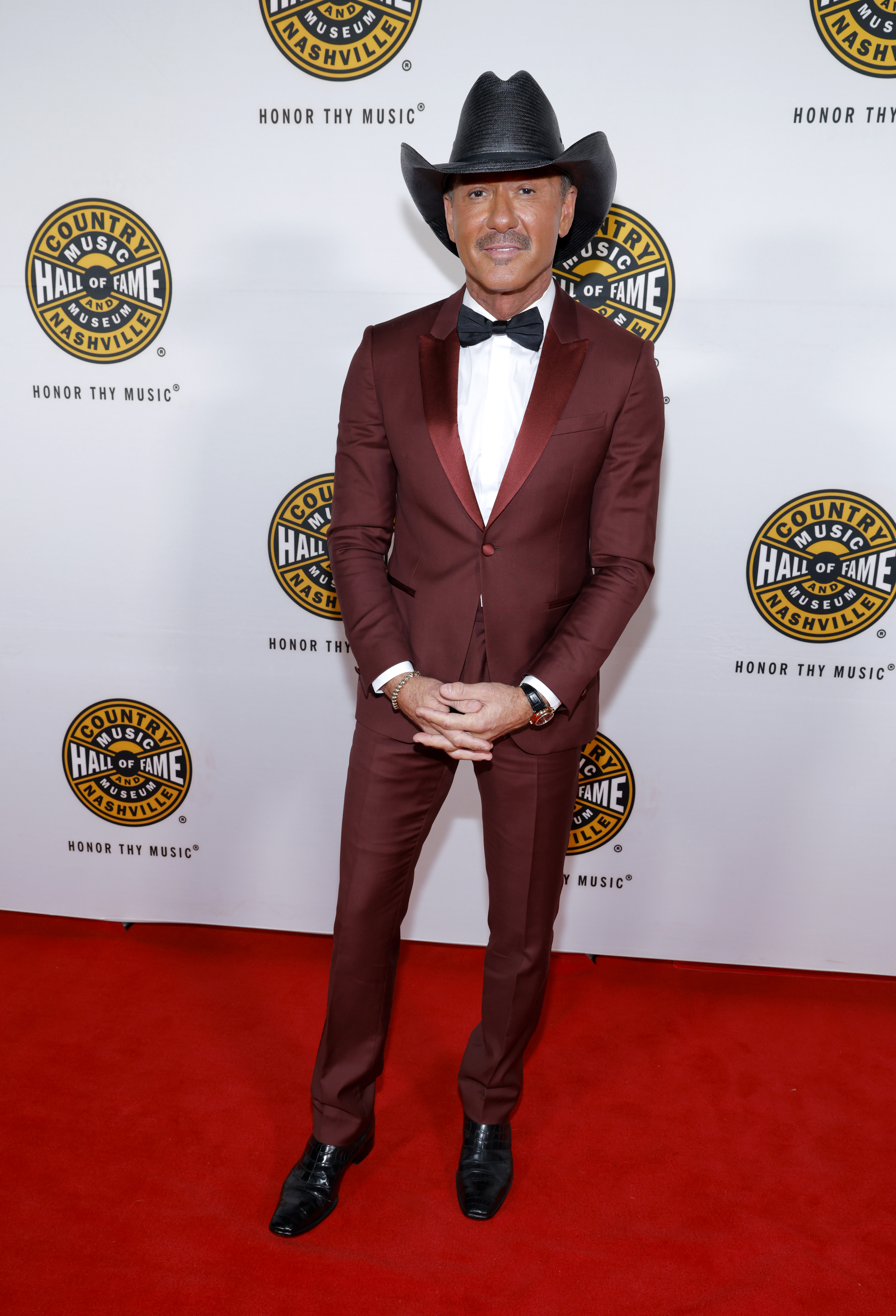 Tim McGraw poses solo in a burgundy suit, black bow tie, and signature cowboy hat at the Country Music Hall of Fame and Museum’s 2026 Medallion Ceremony in Nashville, Tennessee, on October 18, 2026. | Source: Getty Images
