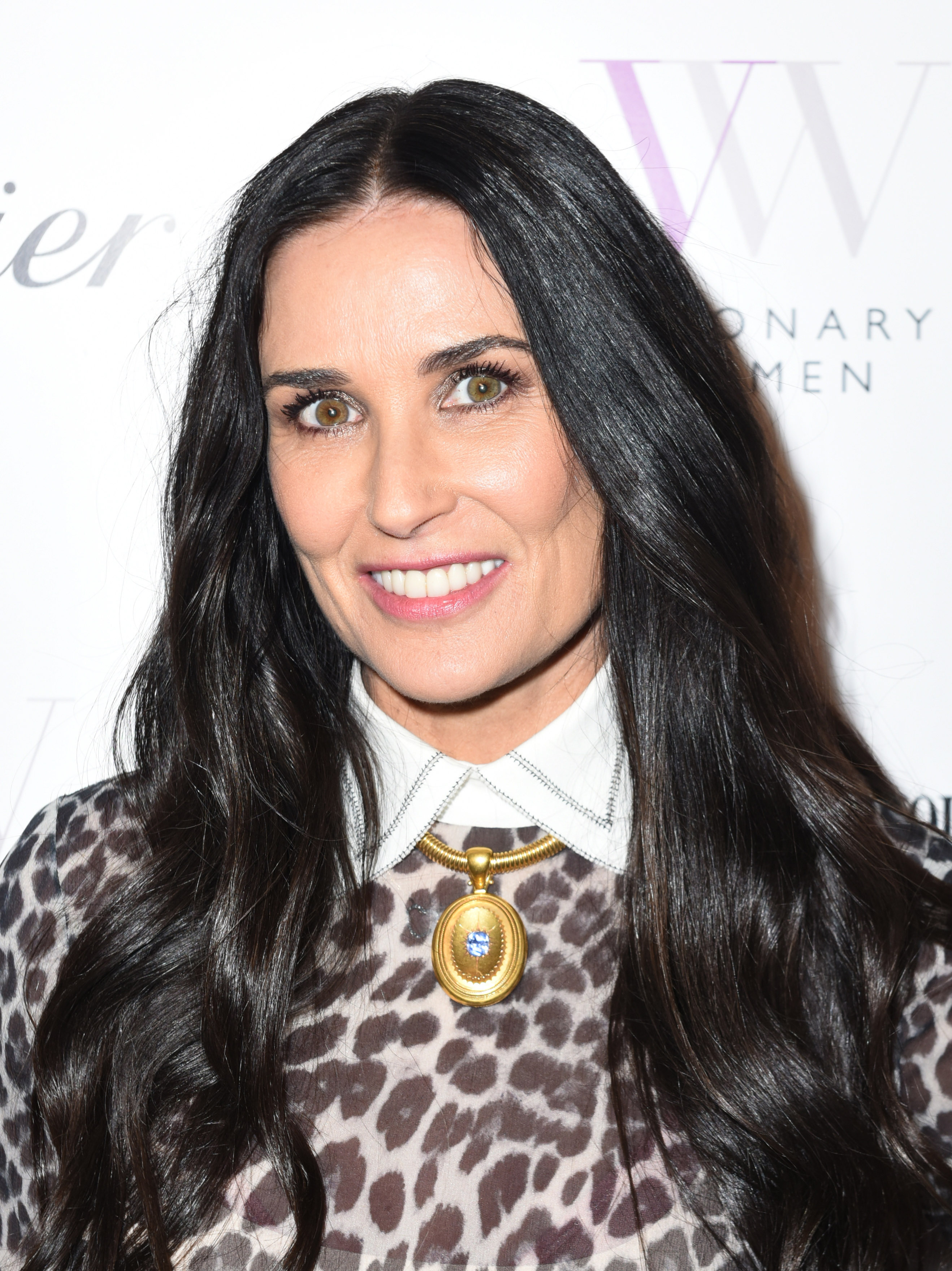 With a radiant smile and striking gaze, Demi Moore stuns in a chic leopard-print ensemble and bold gold pendant. Her dark hair frames her face with classic grace as she embodies confidence and timeless style.