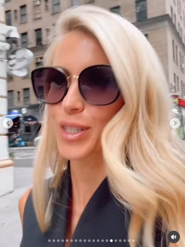 Katie Zacharia walks along a city street wearing oversized dark sunglasses and a black sleeveless outfit, with her blonde hair falling over her shoulders. | Source: Instagram/katiezacharia