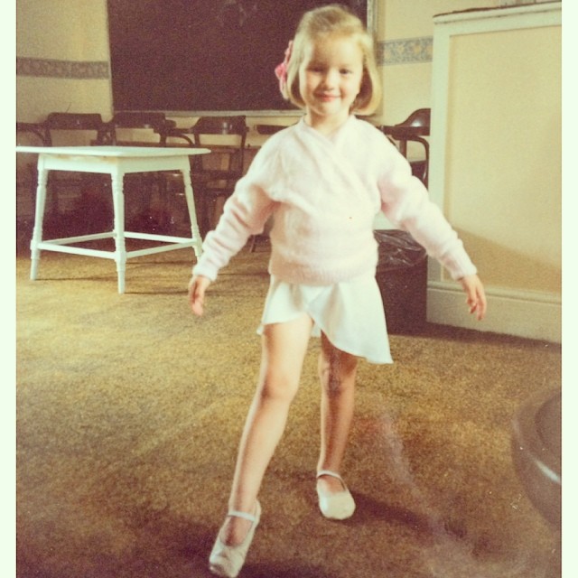 Rosie Alice Huntington-Whiteley poses in a childhood ballet snapshot, smiling in a pale sweater, skirt, and ballet flats. | Source: Instagram/rosiehw