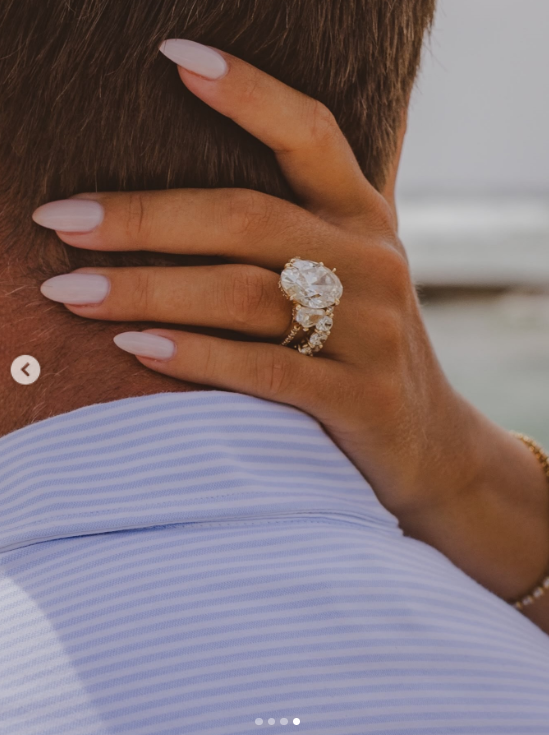 Chrisley rests her hand against Galanis' head, showing off the ring's striking size as her pale pink manicure frames the diamond. | Source: Instagram/ngdiamondgirl