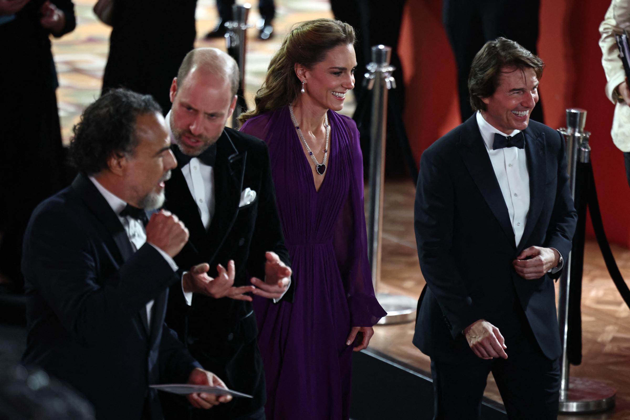 Alejandro González Iñárritu, William, Catherine, and Tom are pictured together during the "Digger" premiere in Leicester Square. Catherine's dark pendant necklace stands out against the purple fabric of her gown.