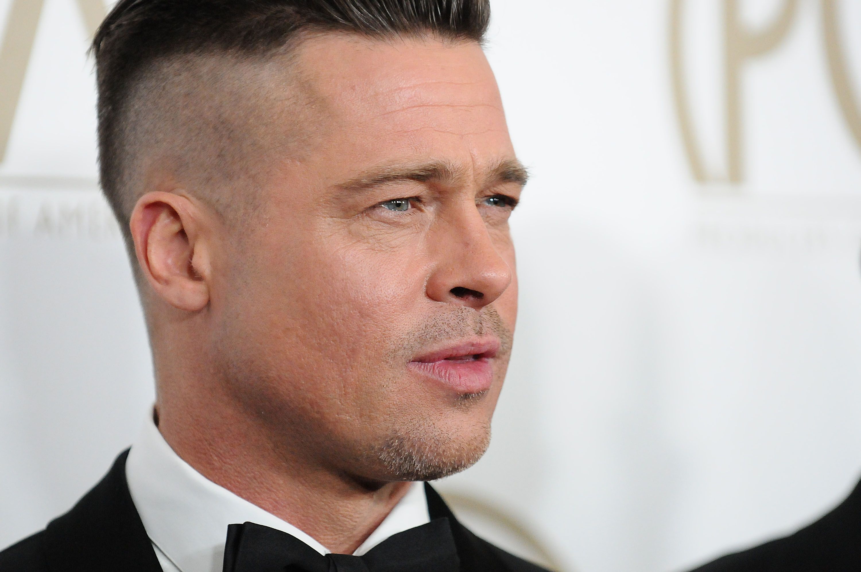 Pitt wore a much shorter hairstyle at the Producers Guild Awards in 2014, with the sides closely cropped and the top swept back. The archival photo offers another point of comparison with the longer, slicked-back style he wore in San Sebastian. | Source: Getty Images