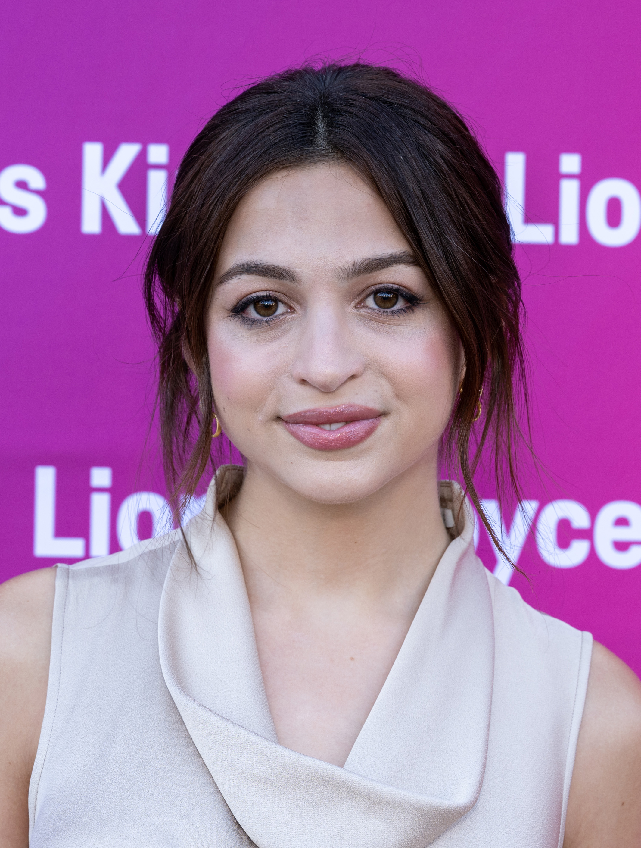 Josie Totah poses at the Film Independent New Wave Actors Panel and Conversation event in a sleeveless, light-colored outfit with a draped neckline. Her dark hair is styled in a loose updo with face-framing strands. | Source: Getty Images