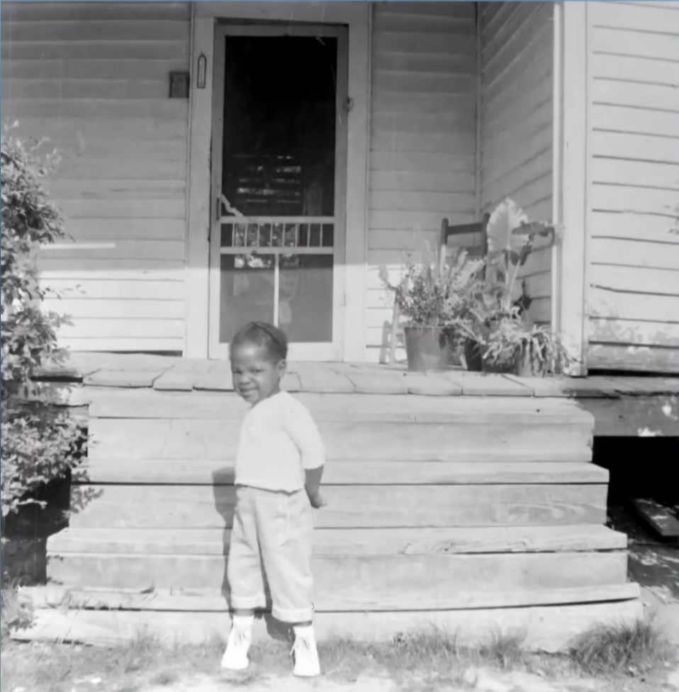 The legendary TV host as a young girl in front of her childhood home, from a video dated April 30, 2021 | Source: YouTube/DoctorOz