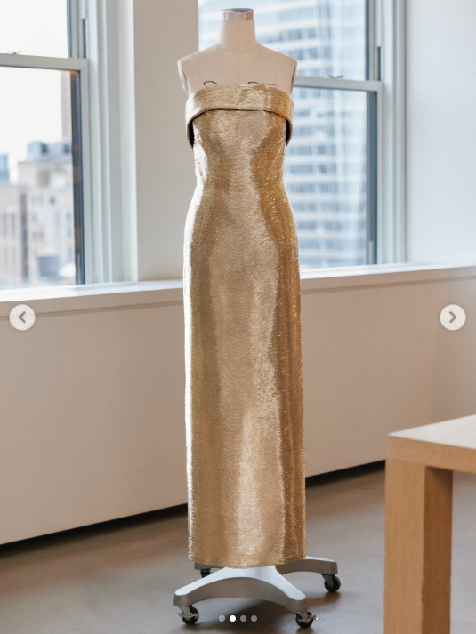 Oscar de la Renta's custom gold bugle-bead gown for Usha Vance is displayed in the fashion house's New York City atelier, offering a full view of its strapless neckline and floor-length column silhouette. | Source: Instagram/oscardelarenta