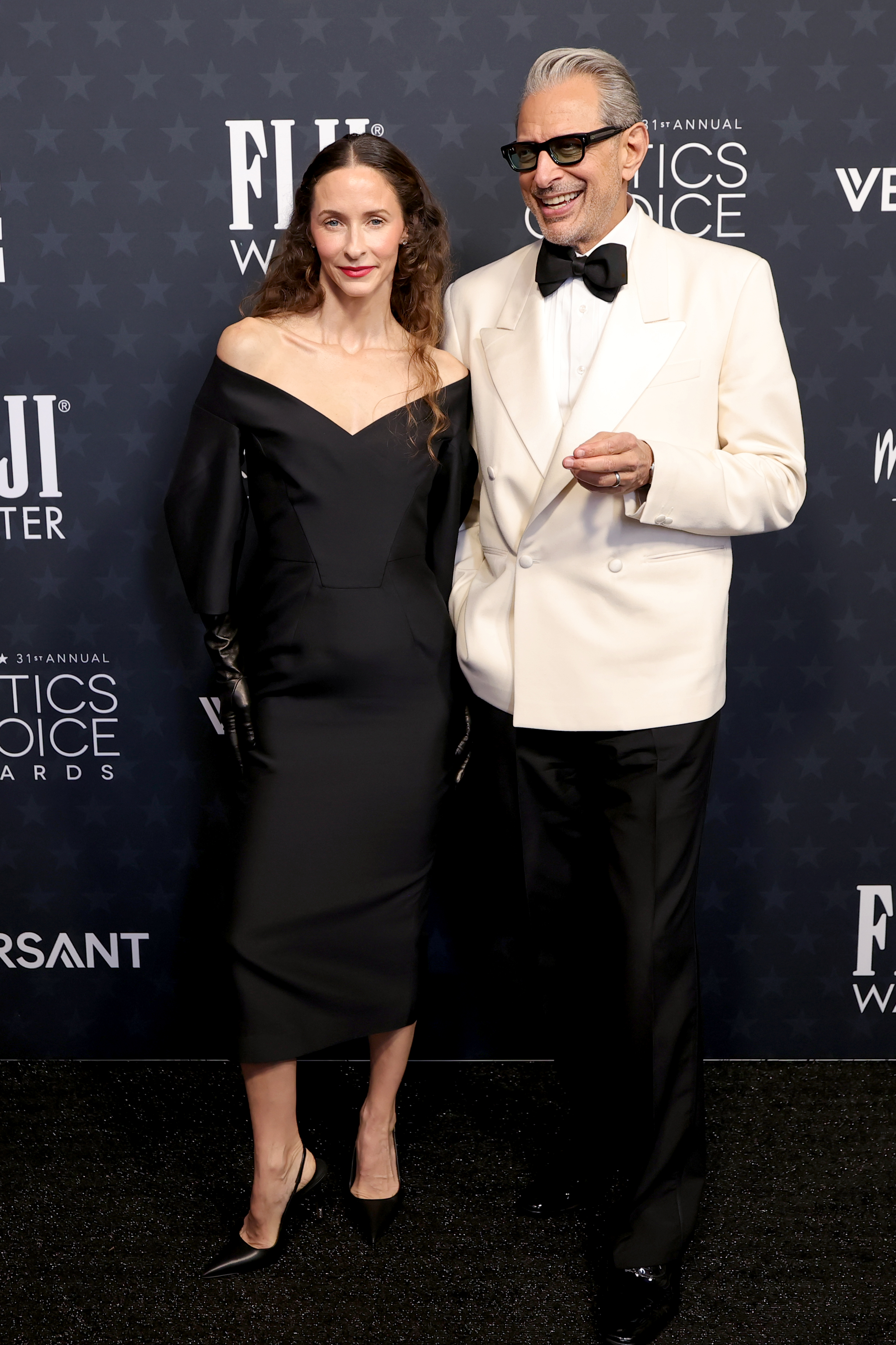 Emilie Livingston and Jeff Goldblum pose together, with her in a sleek black gown and him in a standout white tuxedo jacket | Source: Getty Images