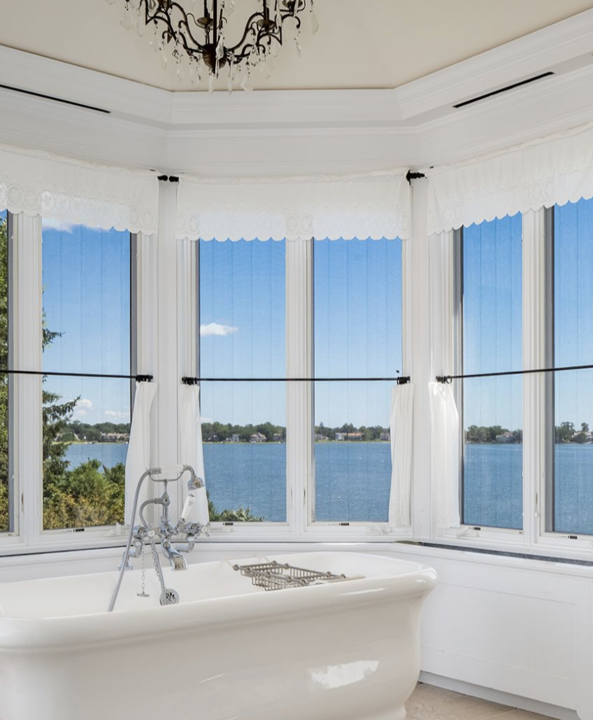 One of Cedar Cliff's luxurious bathrooms features a freestanding bathtub surrounded by tall windows overlooking Long Island Sound — offering breathtaking waterfront views even during a relaxing bath. | Source: Instagram/@brizolisjanzen