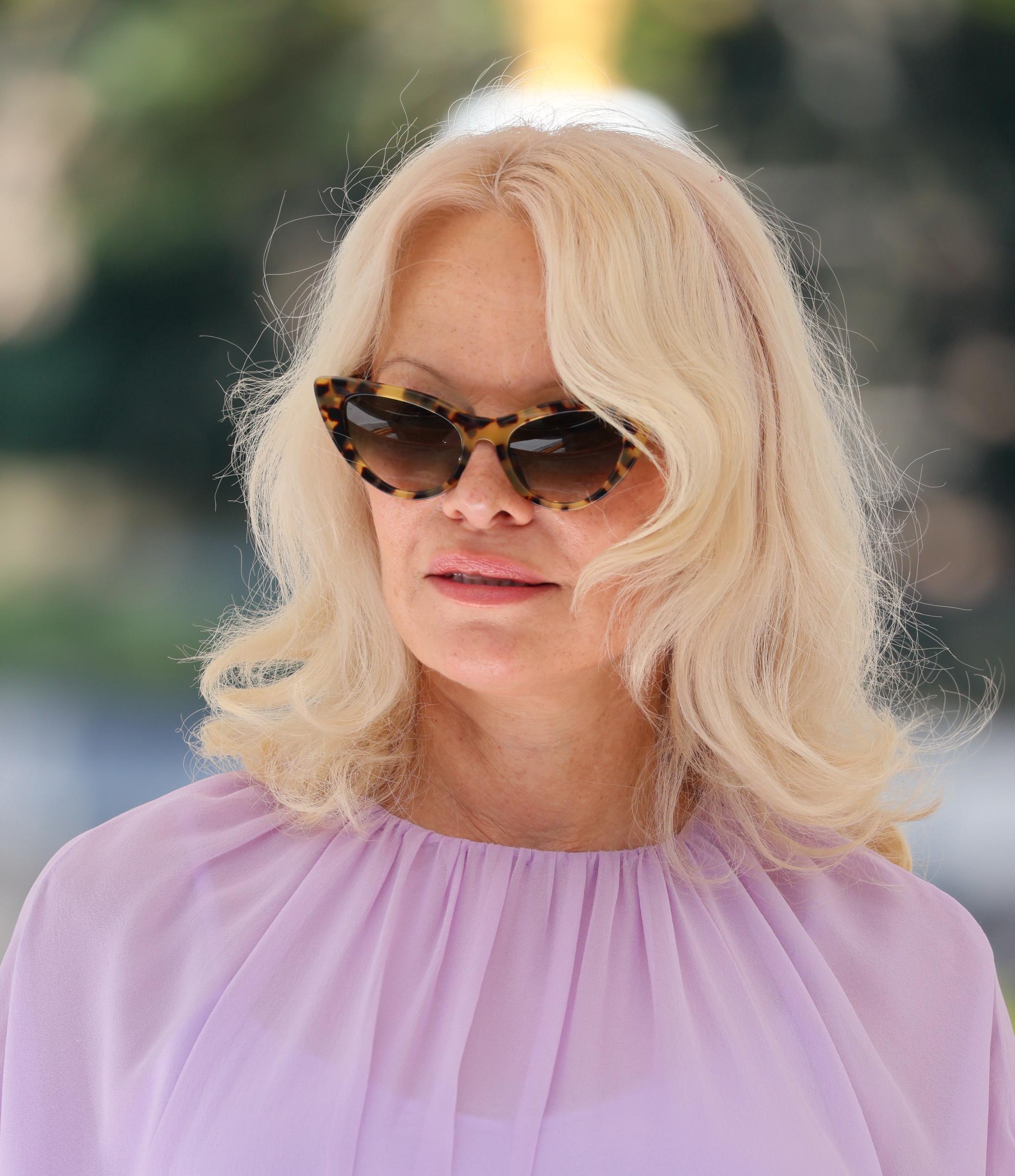 Anderson arrived at the Hotel Excelsior Venice Lido Pier on September 7 in a soft lavender look, one day after accepting amfAR's Award of Courage. Tortoiseshell cat-eye sunglasses complemented her blonde hair, which she wore in loose waves. | Source: Getty Images