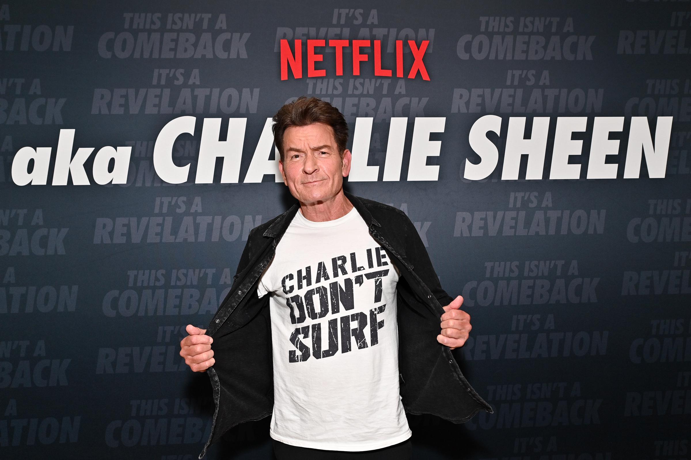 Charlie Sheen attends the premiere of aka Charlie Sheen in a black jacket and graphic T-shirt. | Source: Getty Images