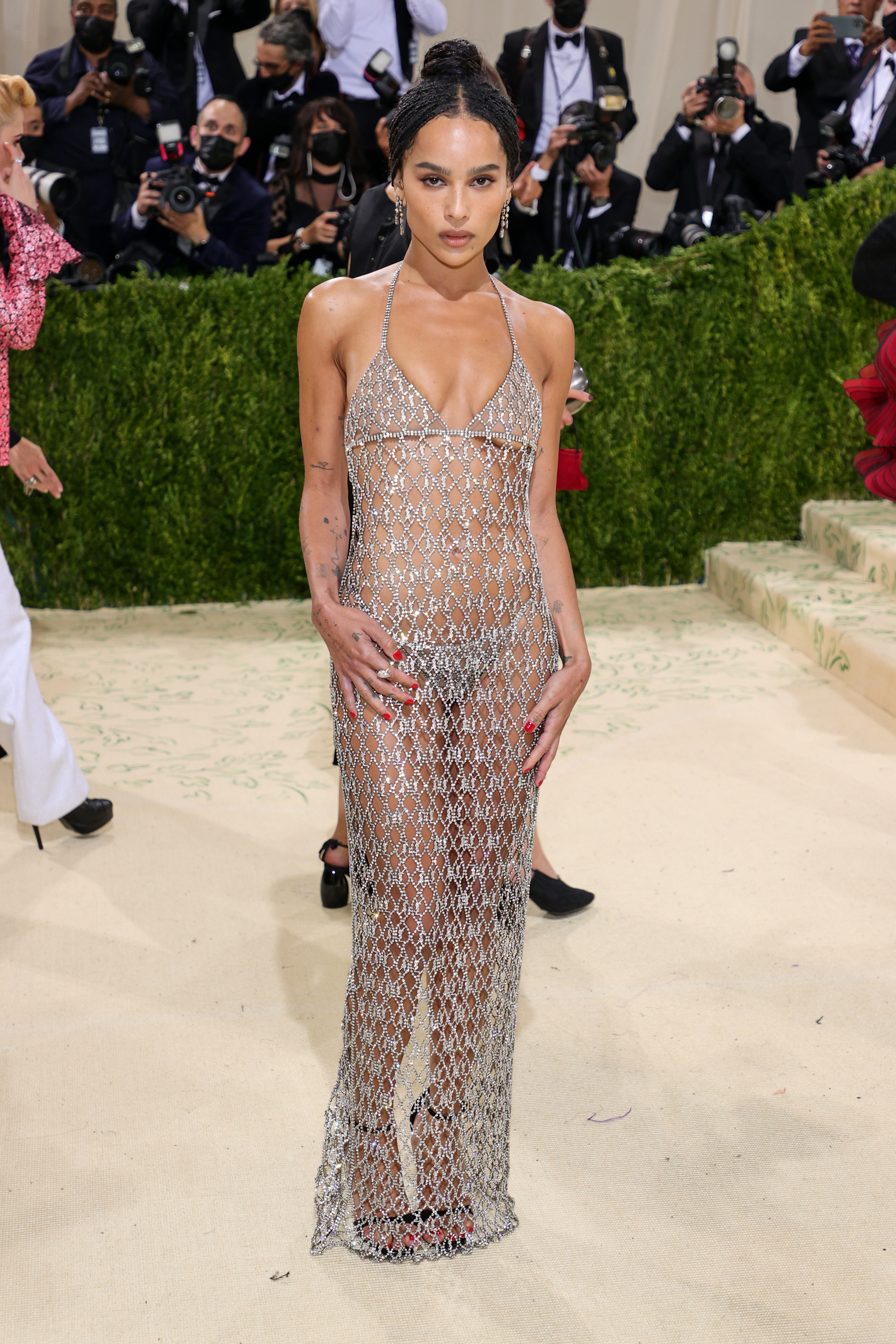 Zoë Kravitz attended the "Met Gala: In America – A Lexicon of Fashion" at the Metropolitan Museum of Art in New York City on September 13. She wore a daring sheer Saint Laurent crystal mesh dress layered over matching silver underwear, styled with a sleek bun, delicate drop earrings, and red nail polish.