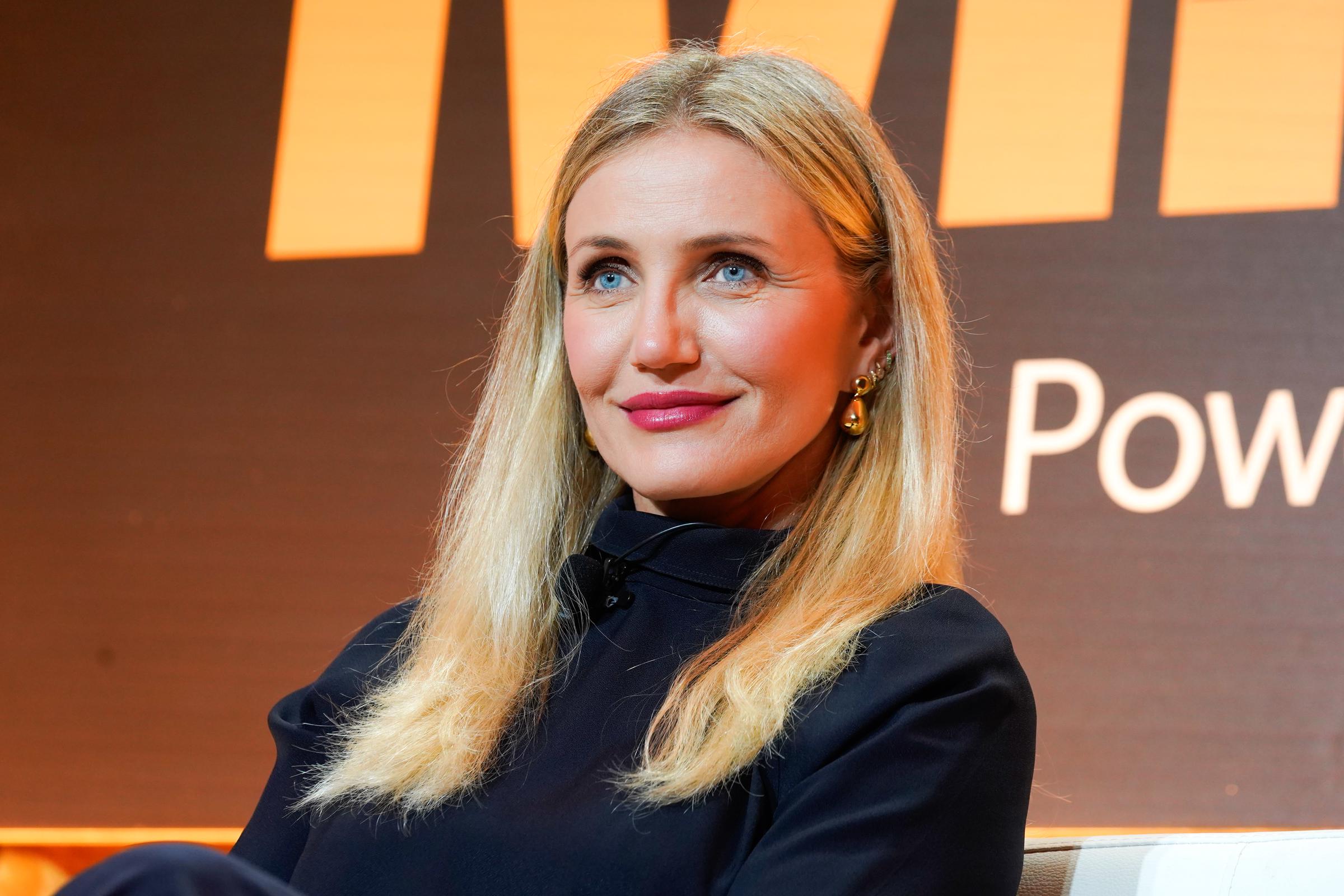 Cameron Diaz speaks at Fortune’s Most Powerful Women Summit, discussing her career evolution and the launch of Avaline, wearing a sleek black outfit with gold earrings and a poised, confident expression.