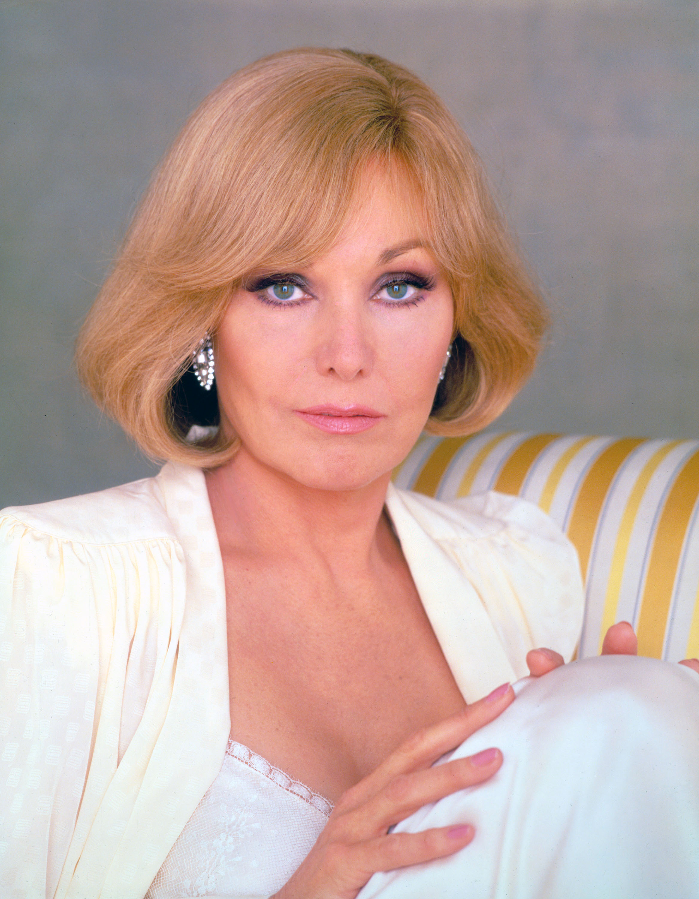 Kim Novak poses in a white outfit with sparkling earrings in a portrait associated with The Mirror Crack'd. | Source: Getty Images