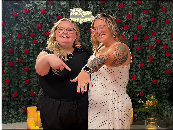 Pumpkin and Alana stand together in front of a rose-covered backdrop, smiling as they extend their hands to display their rings. The sisters share the spotlight in a photo that captures Alana’s presence during Pumpkin’s engagement celebration. | Source: TikTok/Mama P
