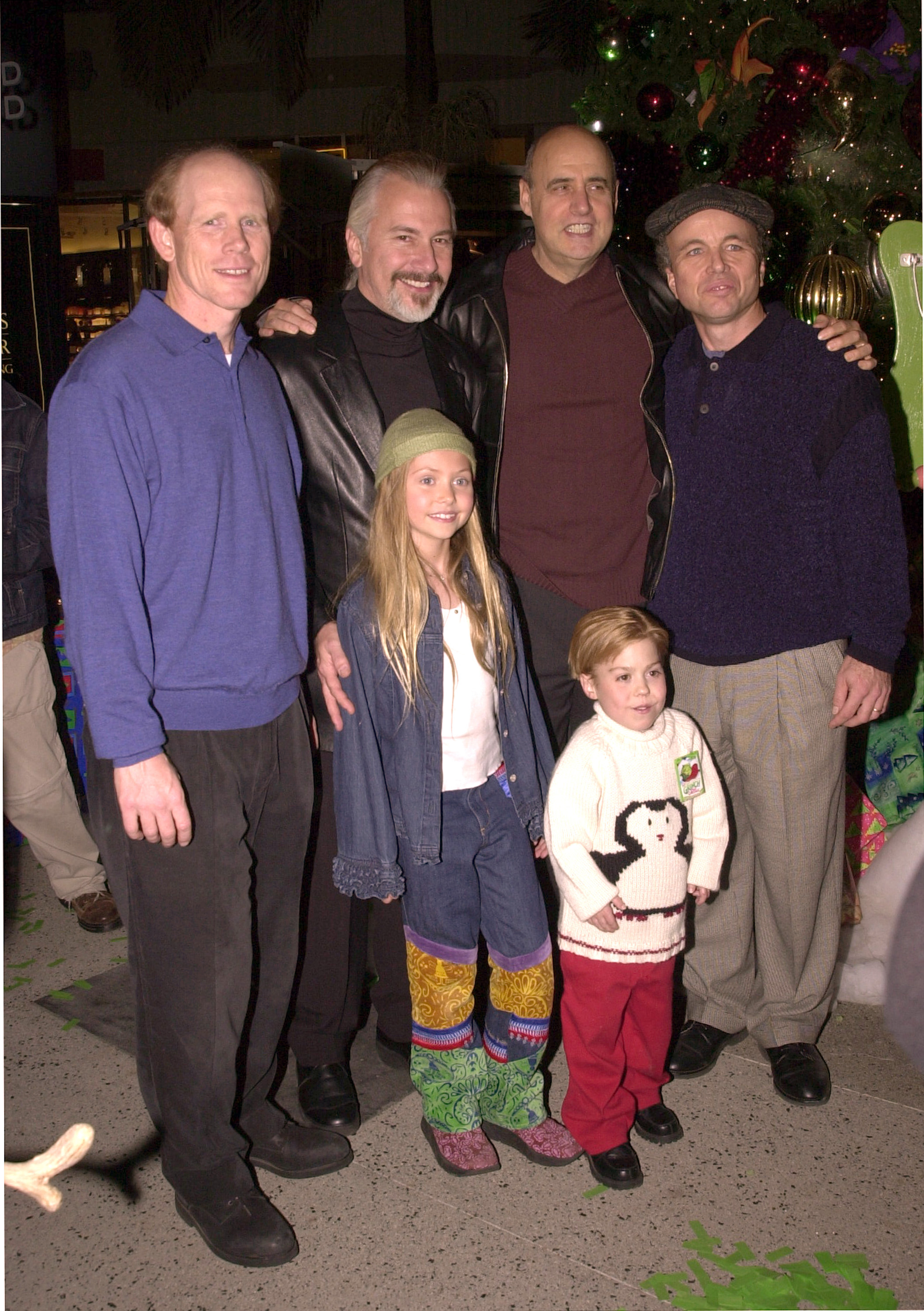 Ron Howard, Rick Baker, Jeffrey Tambor, Clint Howard, Taylor Momsen, and Josh Ryan Evans from "How the Grinch Stole Christmas" pose together at a Hollywood event, looking like a family even offscreen.