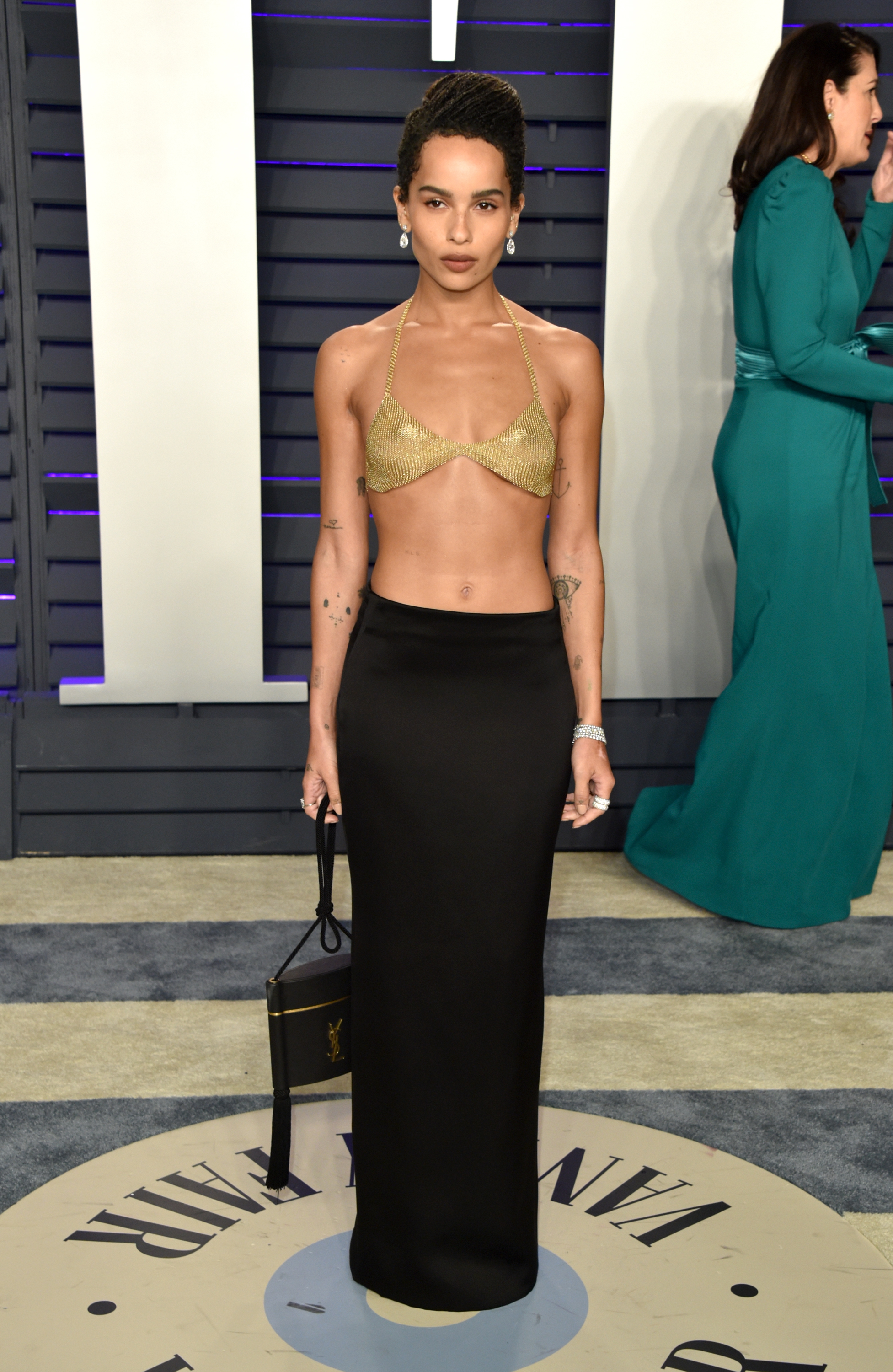 Zoë Kravitz attended the "Vanity Fair" Oscar Party hosted by Radhika Jones at the Wallis Annenberg Center for the Performing Arts in Beverly Hills on February 24. She wore a metallic gold chainmail bra top and a sleek black floor-length skirt, accessorized with drop earrings, stacked rings, and a boxy black clutch.